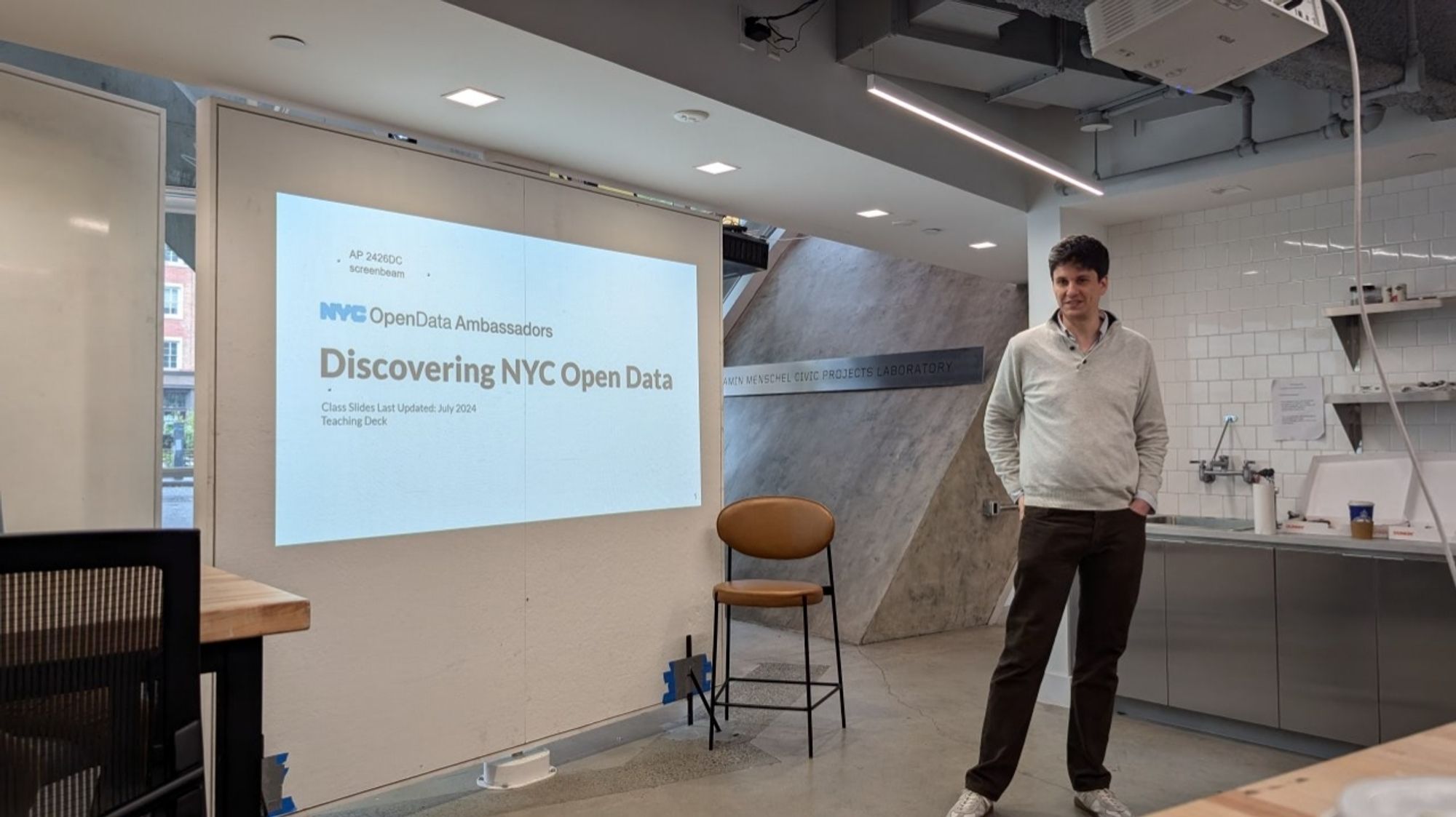 Photo of presenter standing in front of slide titled "Discovering NYC Open Data"