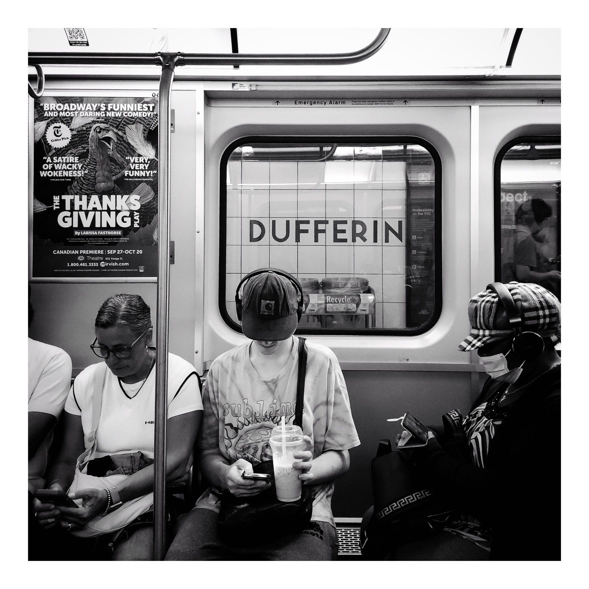 Passengers on an eastbound subway train paying close attention to their phones