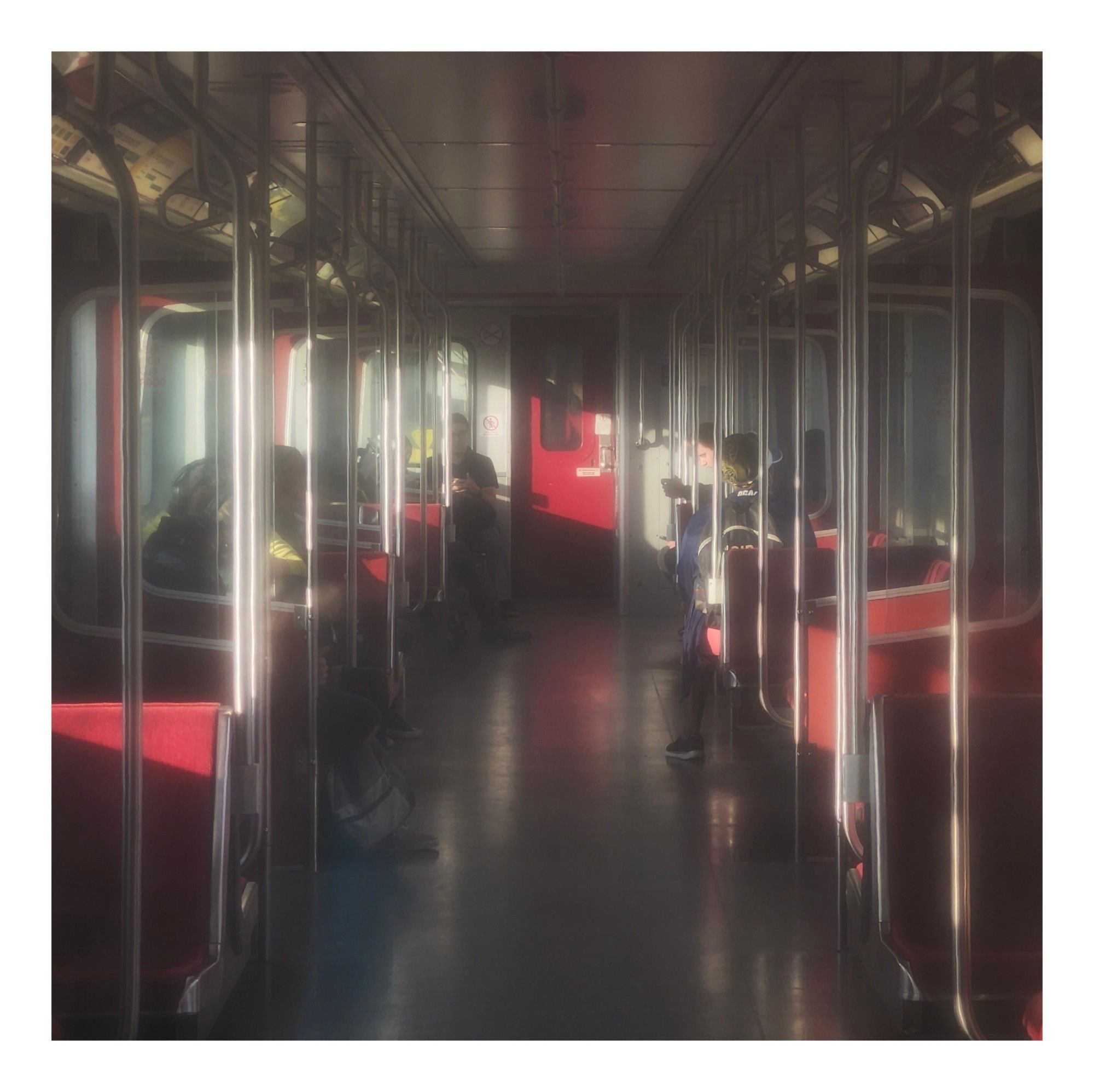 A foggy view of a subway car from the inside of another