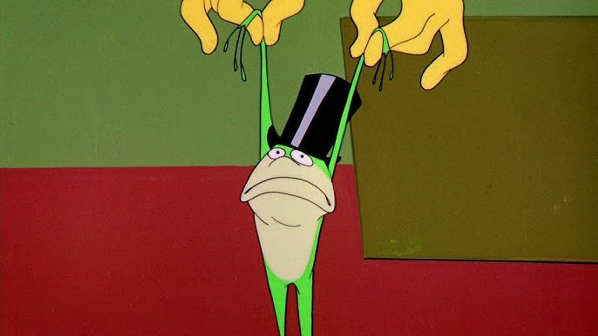 michigan j frog from warner brothers being held up by his arms, limly, and frowning in his top hat