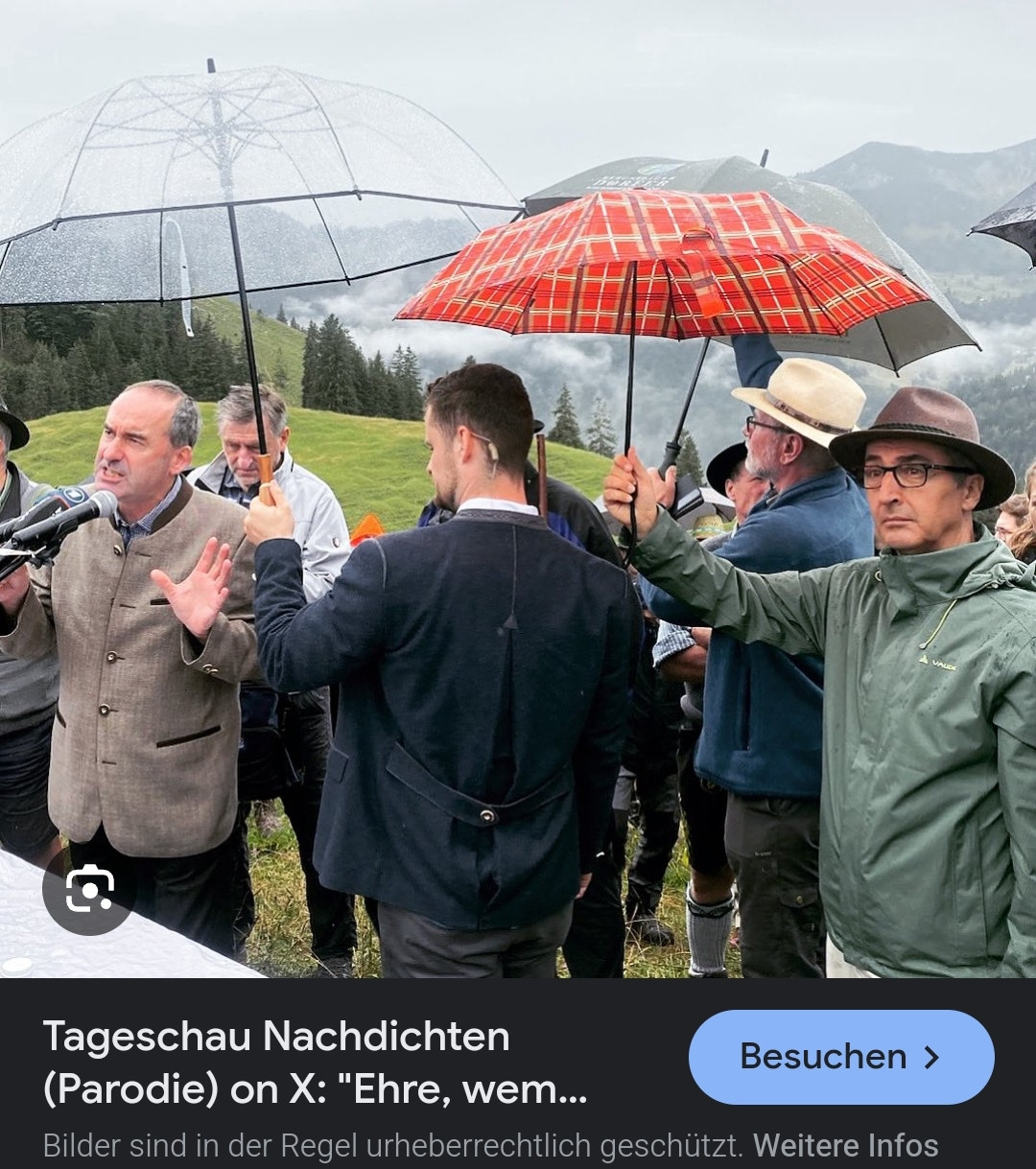 Cem Oezdemir halt dem Bodyguard von Aiwanger im Regen den Regenschirm hin.