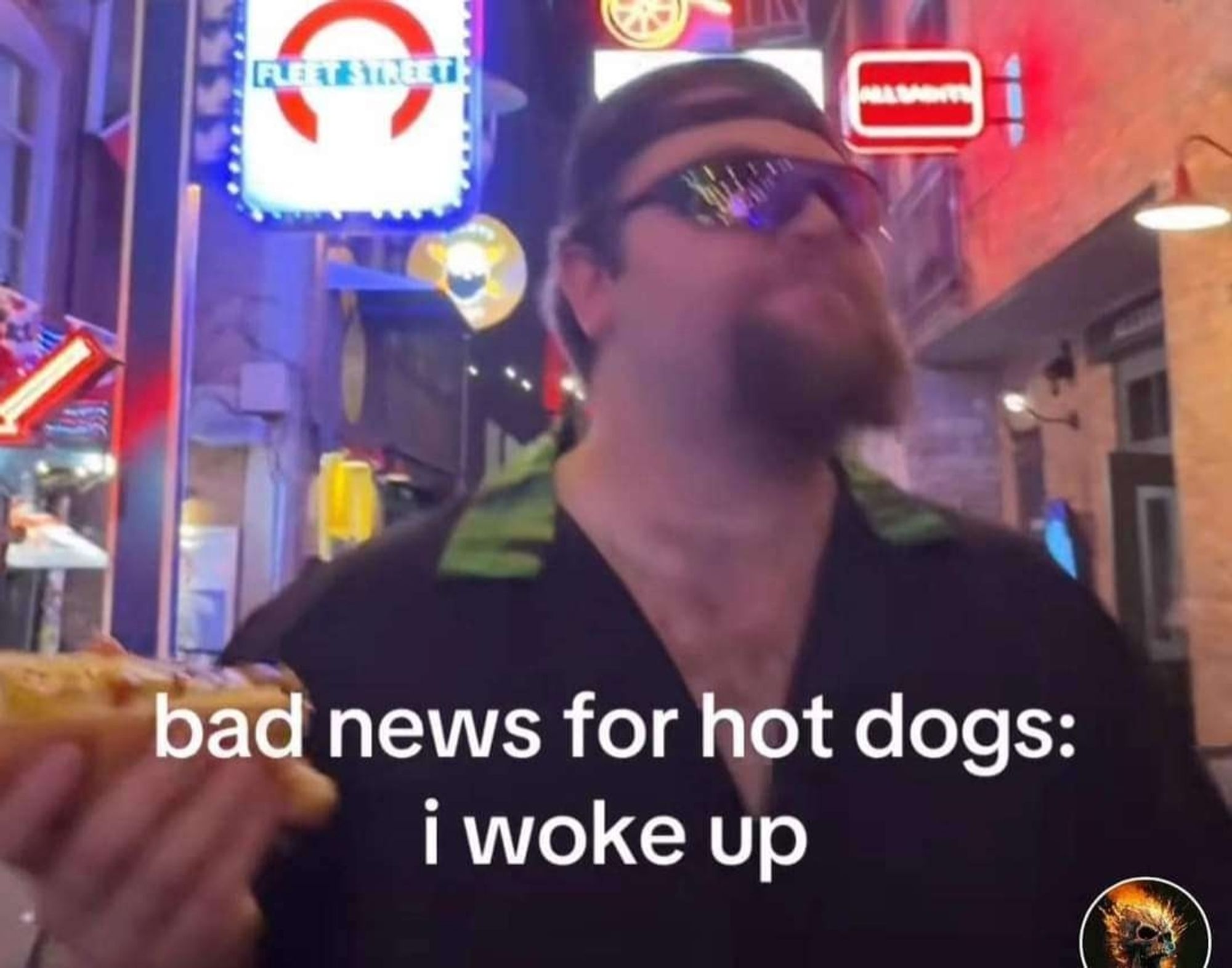 Man on the street with a goatee, sunglasses and backwards baseball cap, holding a hotdog. Text underneath reads "bad news for hot dogs: i woke up"