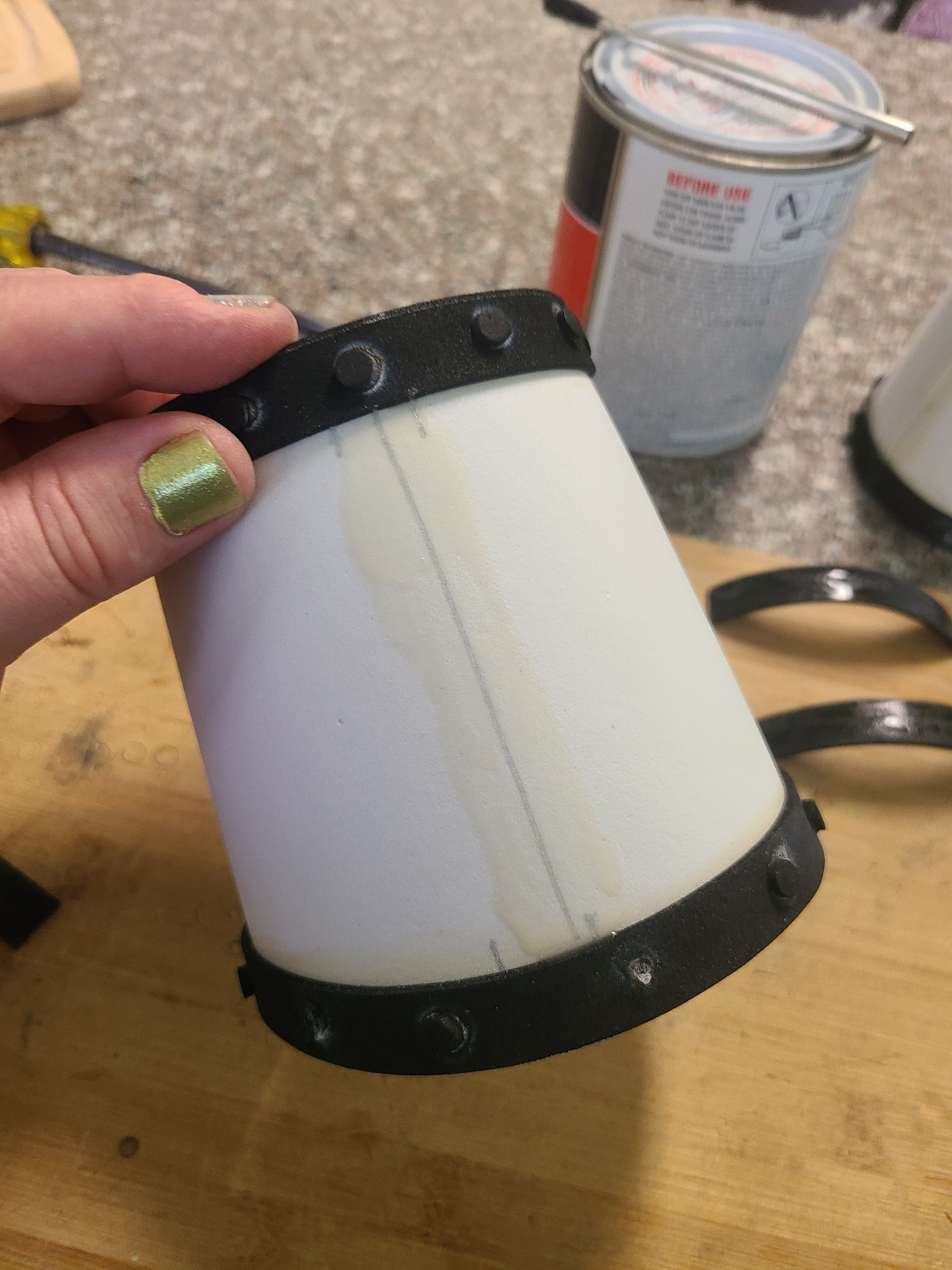 A close up of a bracer, that has a location line drawn on it a few a strip of fresh glue. You can see my thumb as well, along with a nice bright green polish on it for St Patrick's Day.