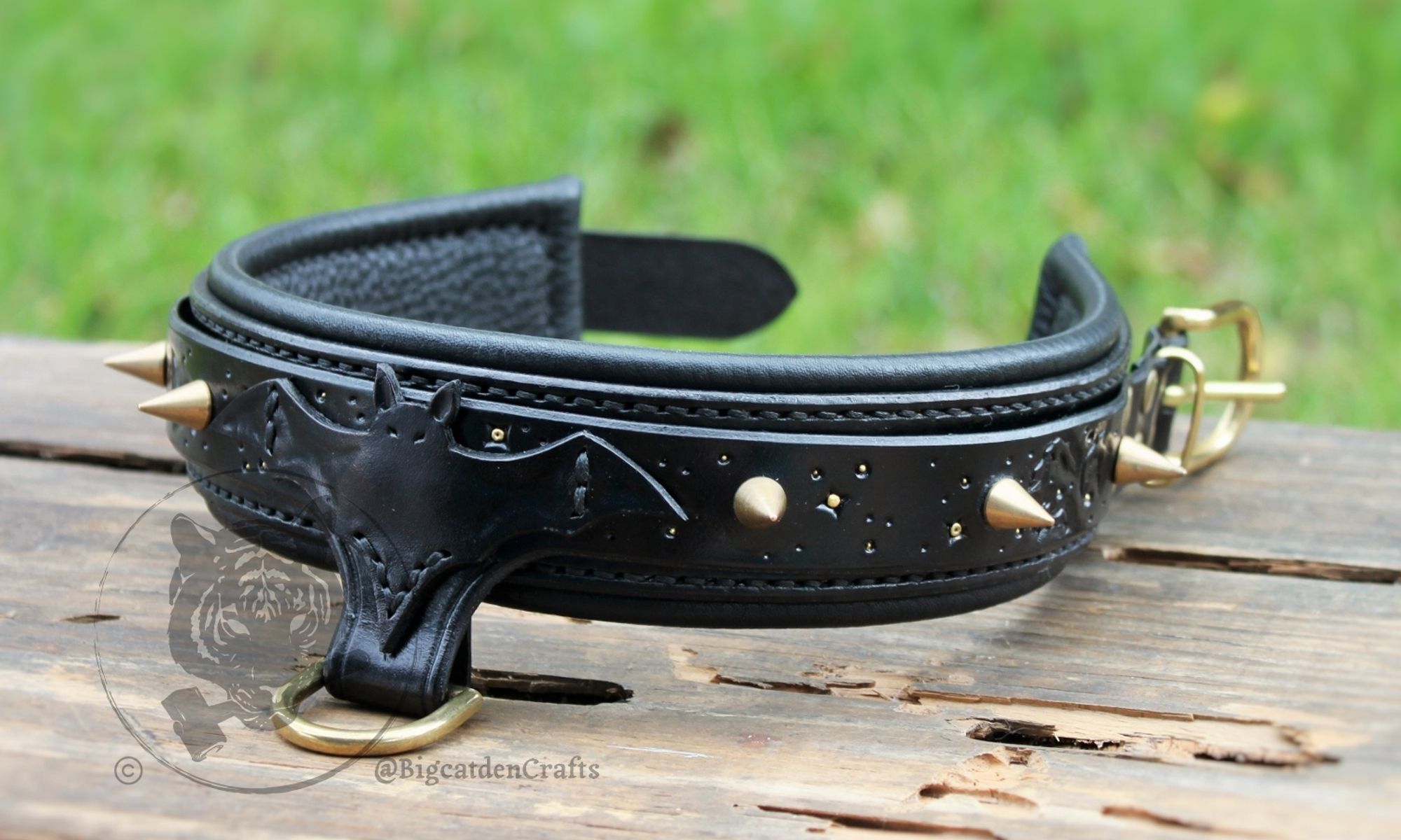 Overall view of the collar sitting on an aged, wooden surface. Groups of bats fly silhouetted against a dark, night sky lit only by golden stars, spikes line either side of this collar, and rolled leather lining gives the wearer all the comfort they could need.