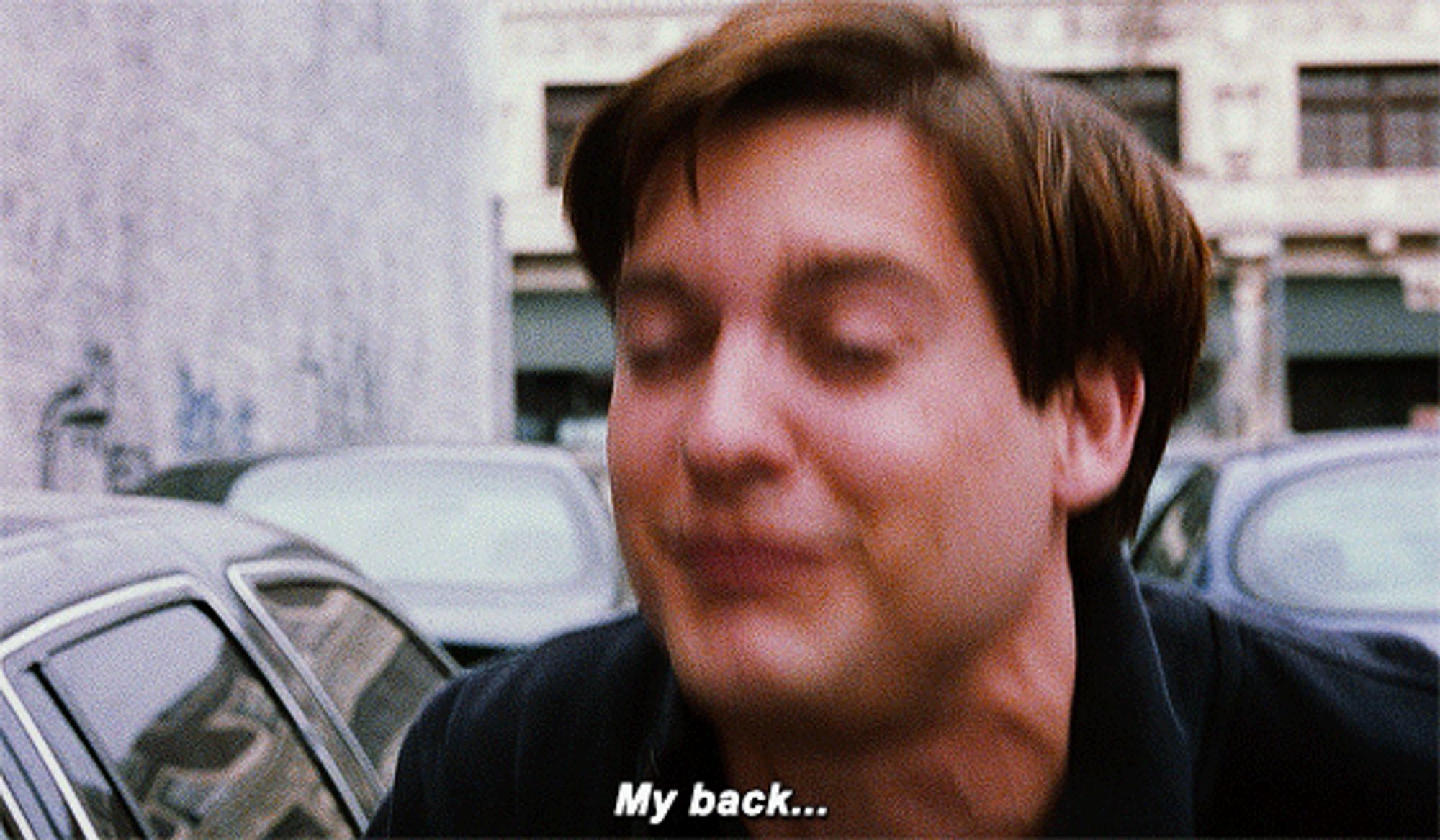 Tobey Maguire’s Peter Parker winces in pain and groans “My back!” after falling off a roof and bouncing off a car.