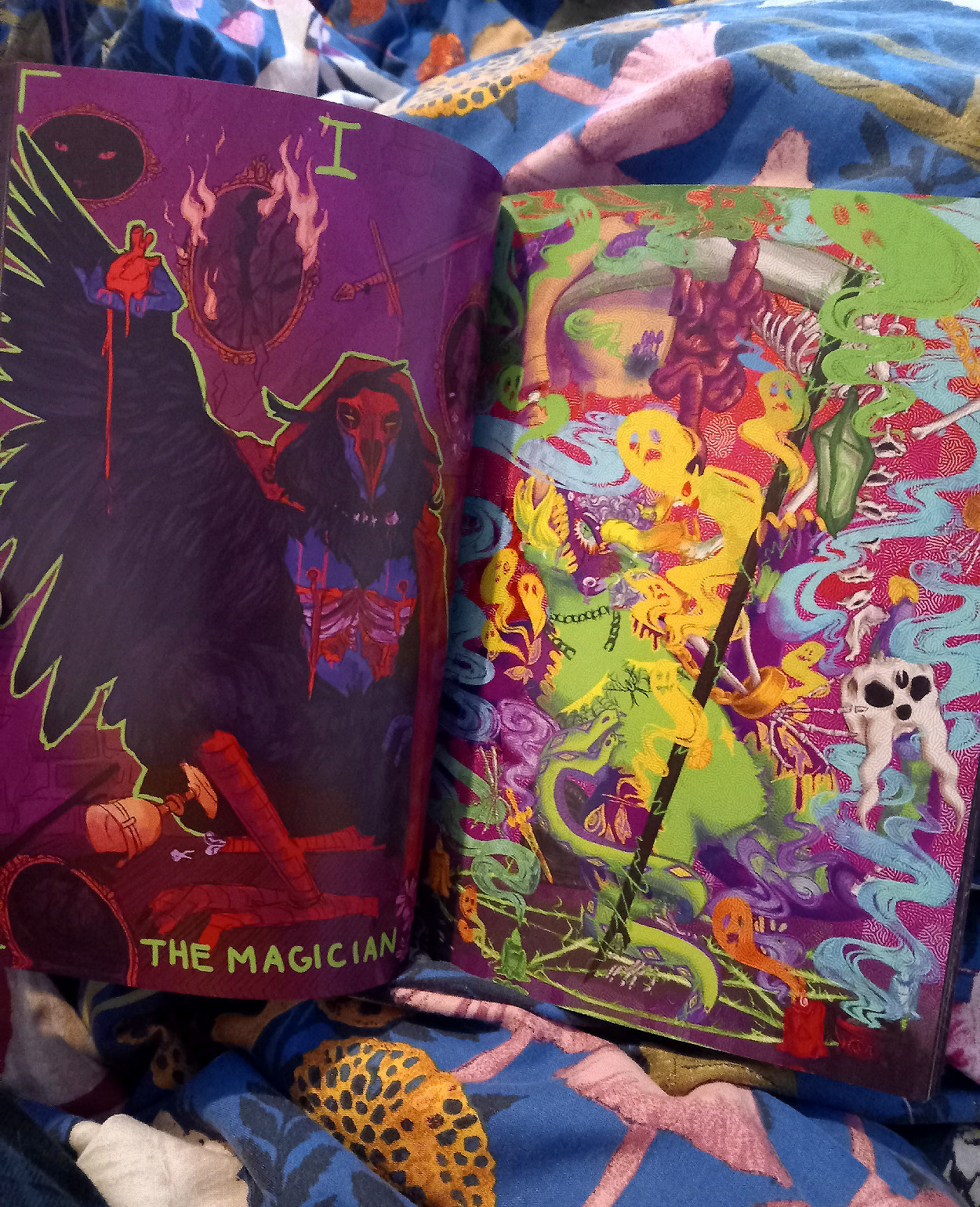 Interior photo from the World Beyond the Veil transmasc horror zine, showing on the left page a birdlike figure holding an anatomical heart in their hand, and on the right a colorful and more psychedelic piece featuring ghosts and gore.