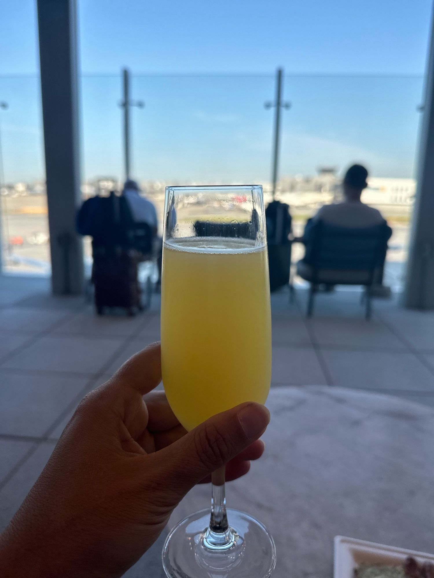 A mimosa from the SkyLounge patio with planes in the background