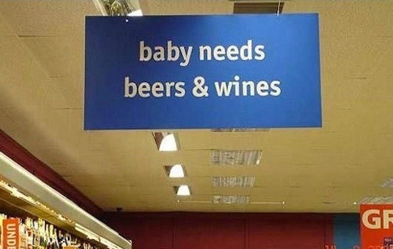 The sign from an aisle in a store saying 
“baby needs
beers & wines”