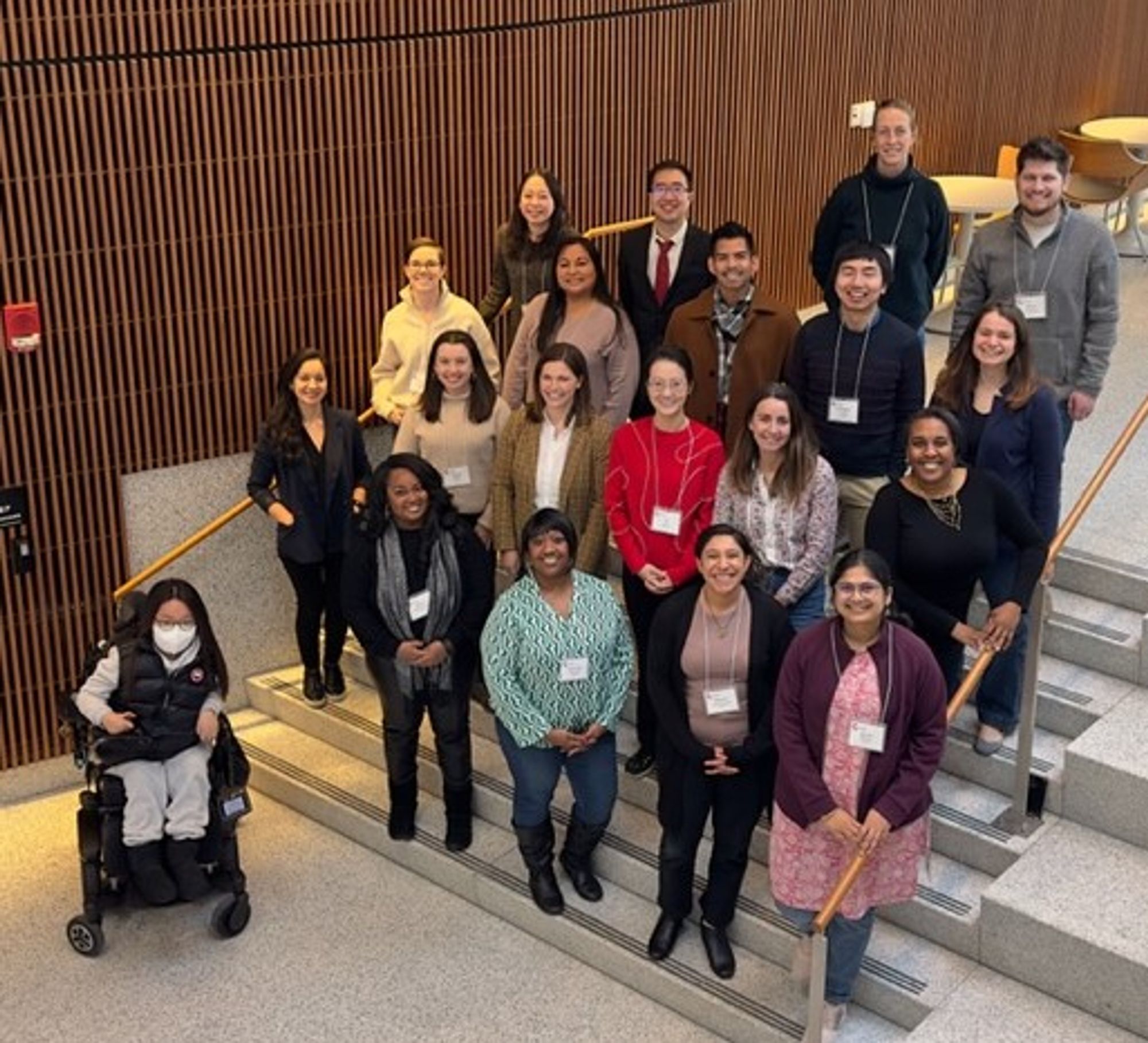 Group of 20 smiling early career scholars on stairs.