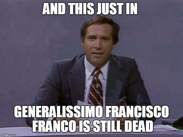 Chevy Chase sitting at the Saturday Night Live weekend update desk. Text above and below him reads, “and this just in: Generalissimo Francisco Franco is still dead.”