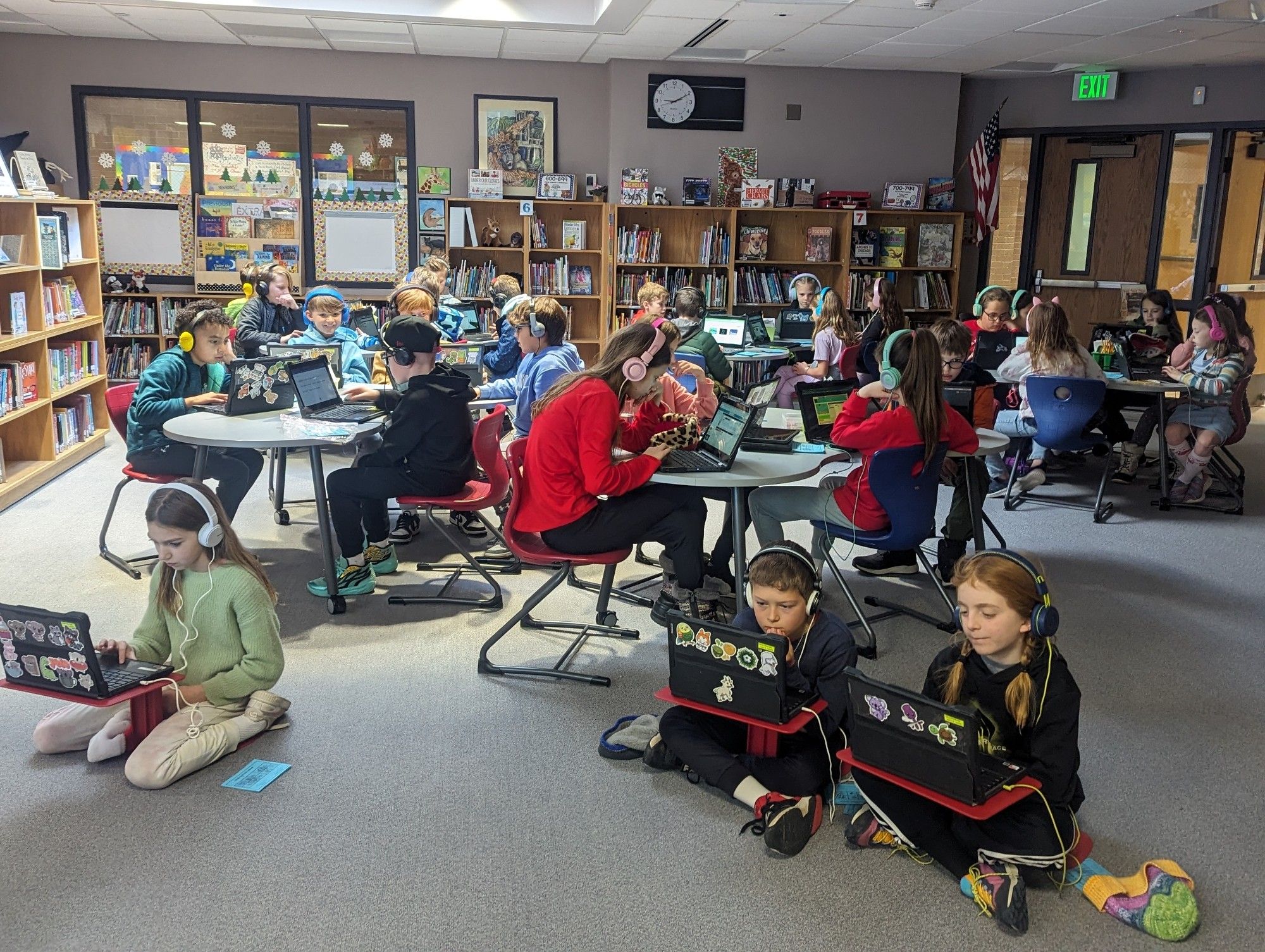 Elementary students enrapt in their Chromebooks, learning to code in the school library.