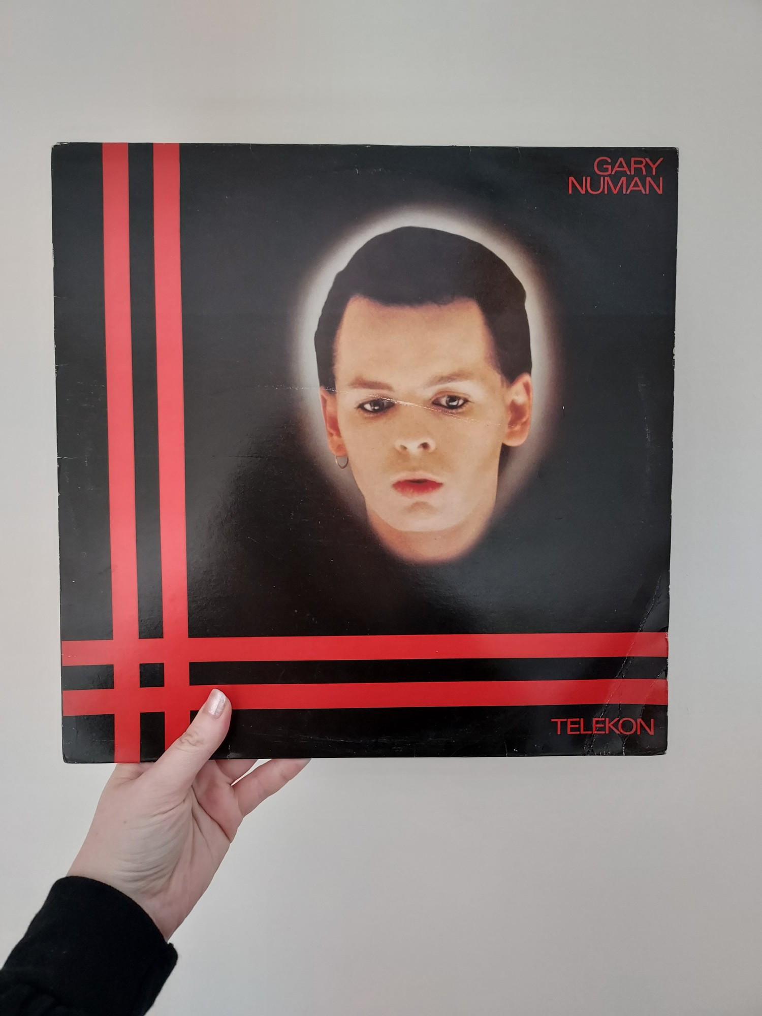 Aimee holds a vinyl record of Gary Numan's Telekon record.