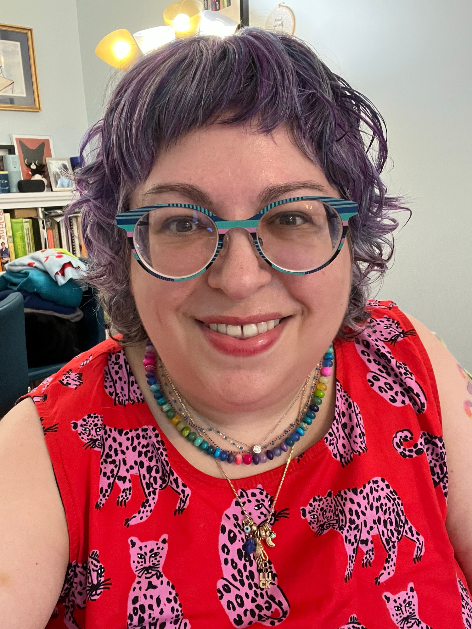 Selfie of a white lady with cool glasses and a red dress with pink leopards