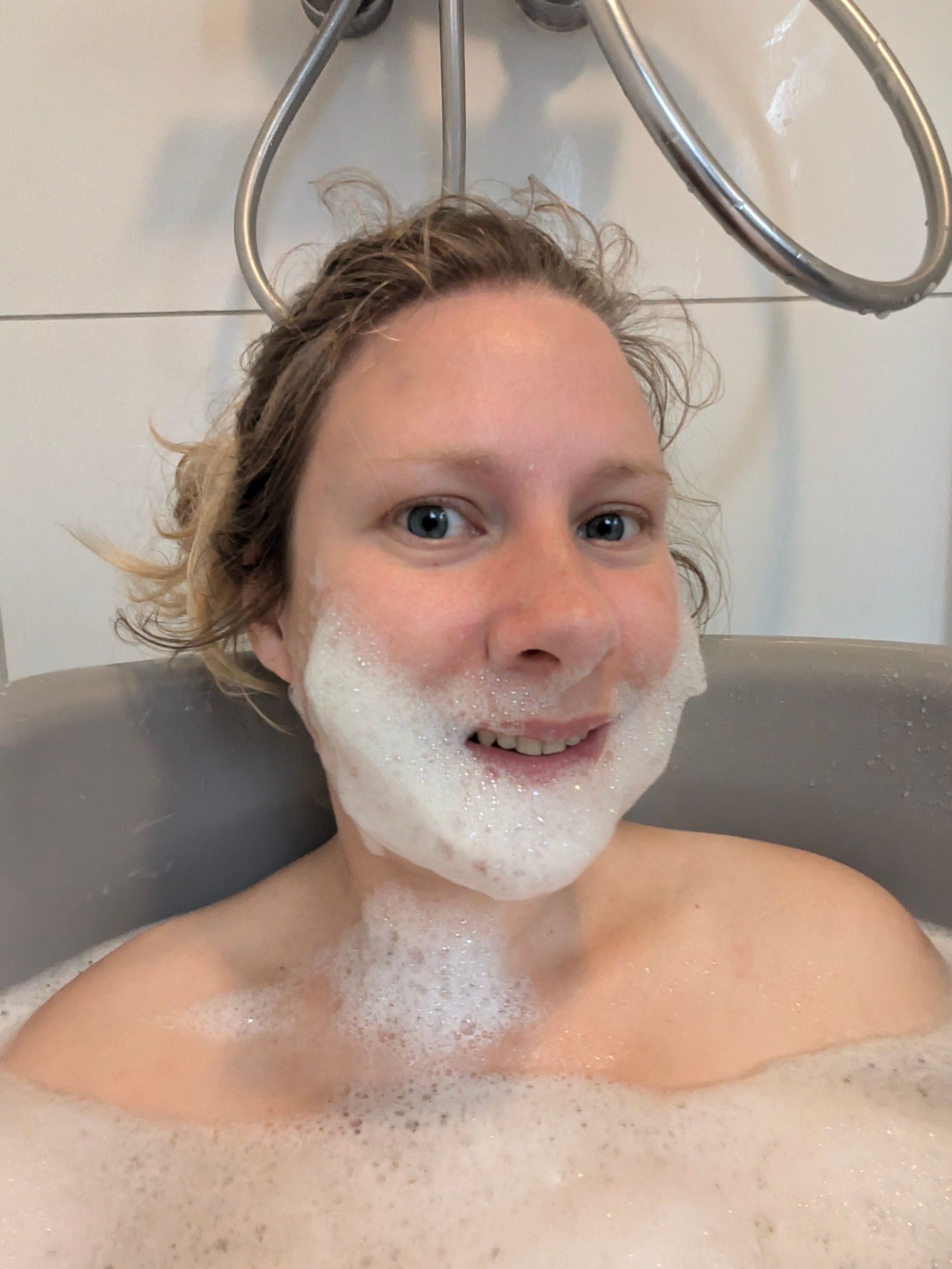 Selfie van vrouw in tobbe met een baard van zeepsop