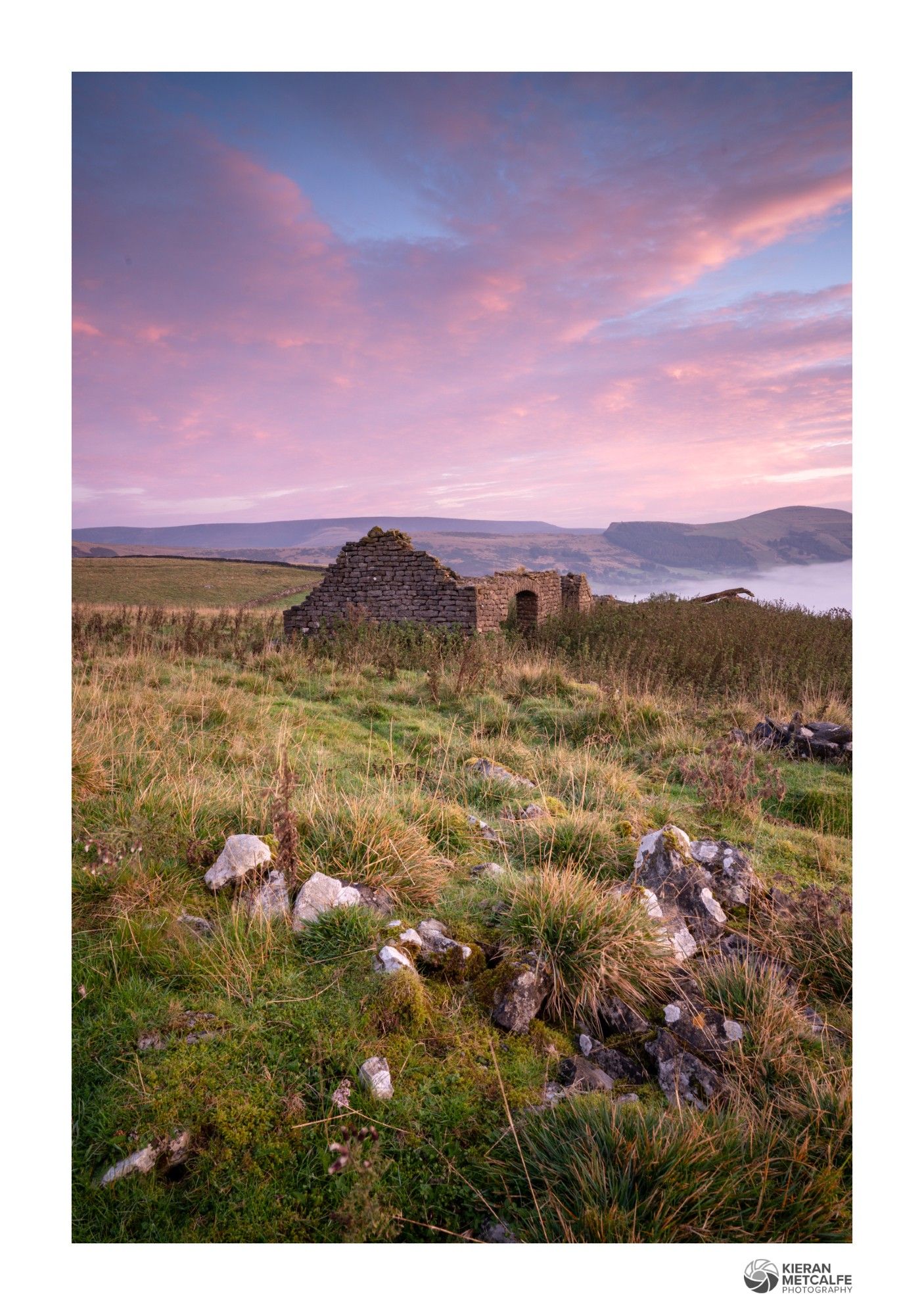 Sunrise at the remains of an old barn in the peak district. High clouds are catching a soft pink glow.