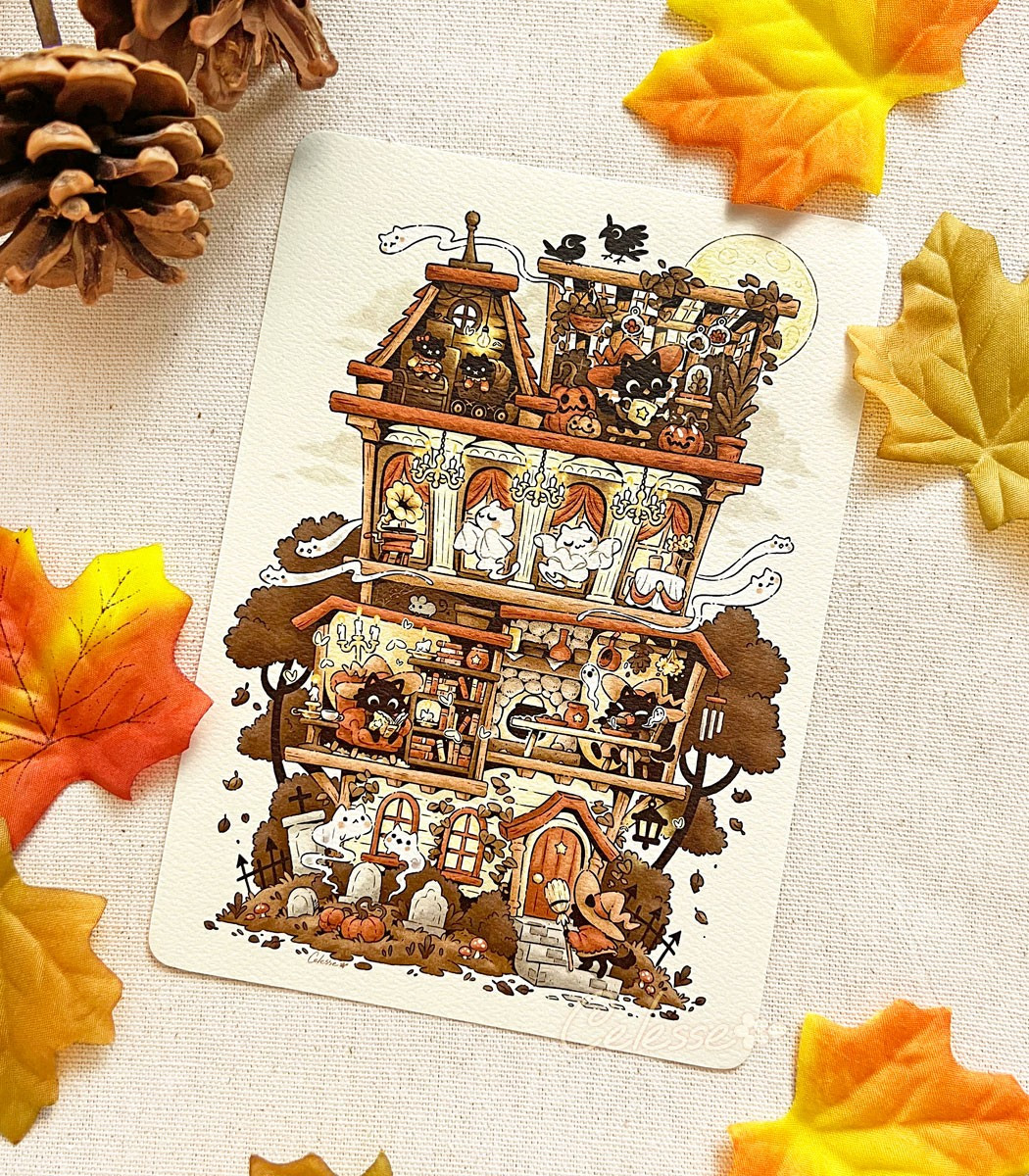 A photo of an art print laid on a table with fall leaves and pine cones around it. The print is of art of a haunted home, featuring dolls in the attic, a moonlit conservatory with living pumpkins, a ballroom with dancing cat ghosts, a moth-bitten library, a dining room with a fireplace, and a cemetery in the front yard. Most rooms are occupied by a small black witch cat.