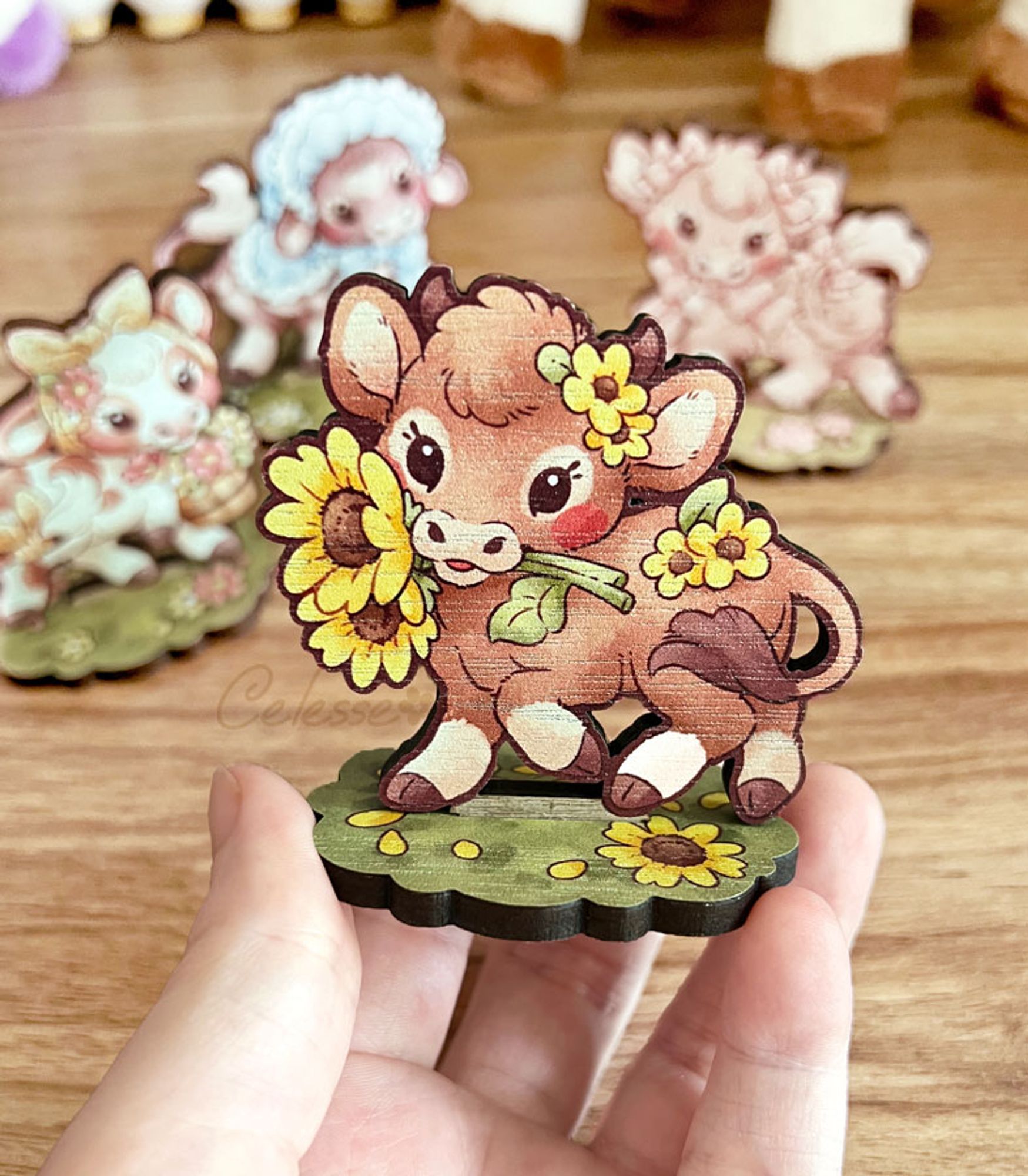 A photo of a wood standee featuring a baby brown cow holding sunflowers in their mouth and trotting on a patch of grass