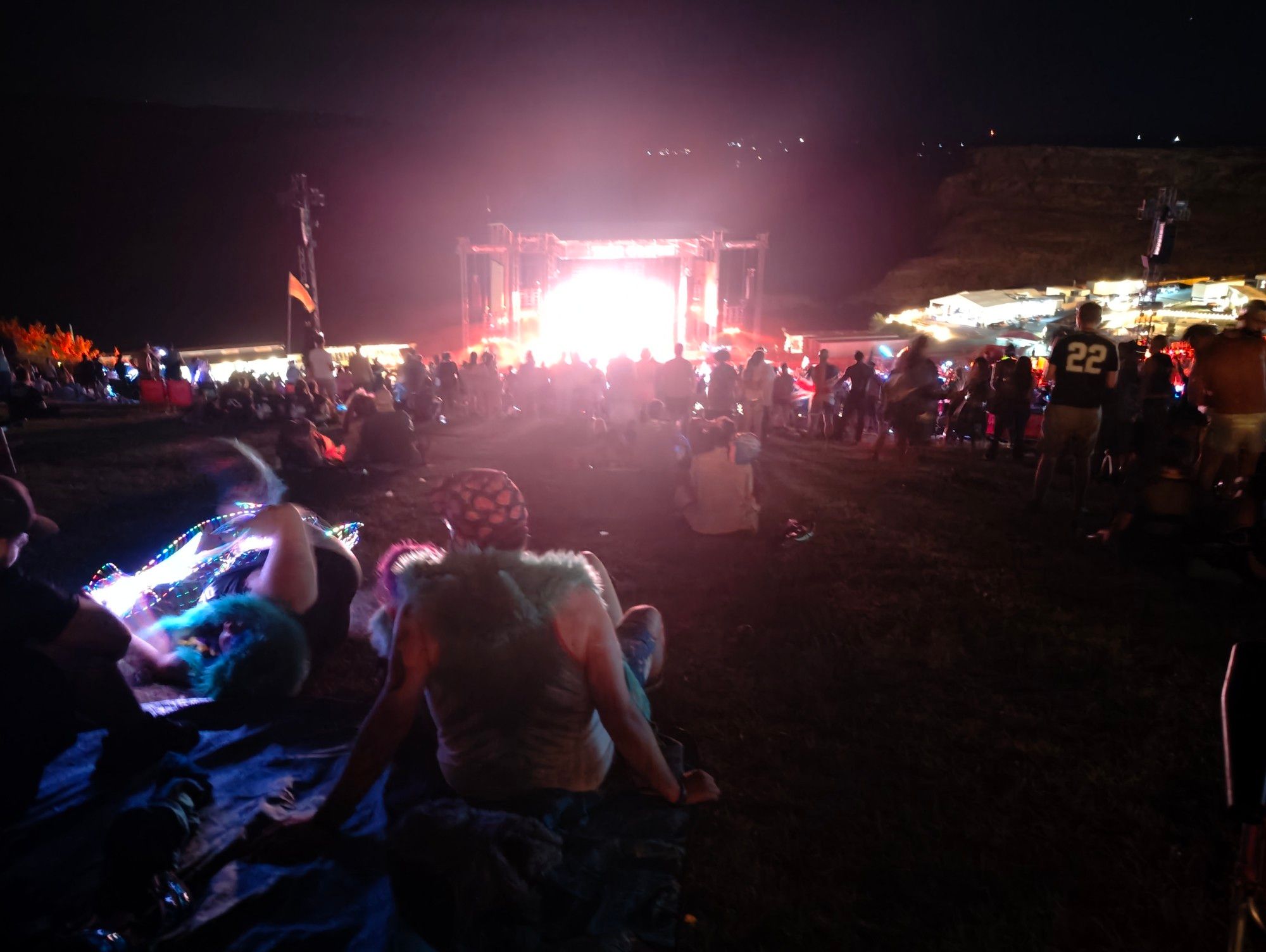 The stage at above and beyond weekender at the gorge. Night time, bright LED wall, with thousands of people. Image looks reminiscent of sunrise. 