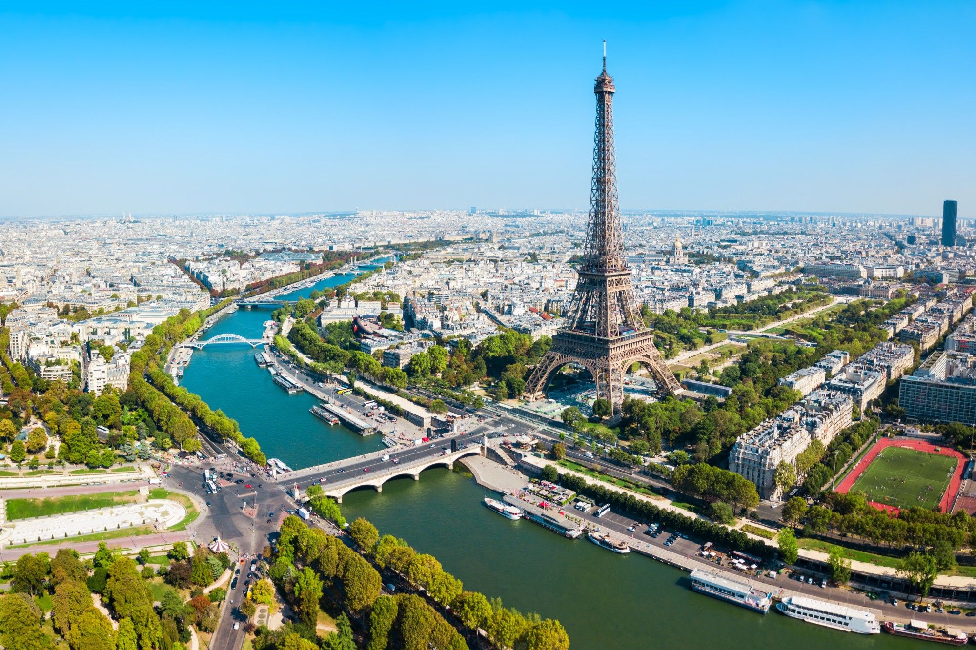 La Seine river (France) flowing through the densely populated city of Paris, with the Eiffel Tower in the background on the bank