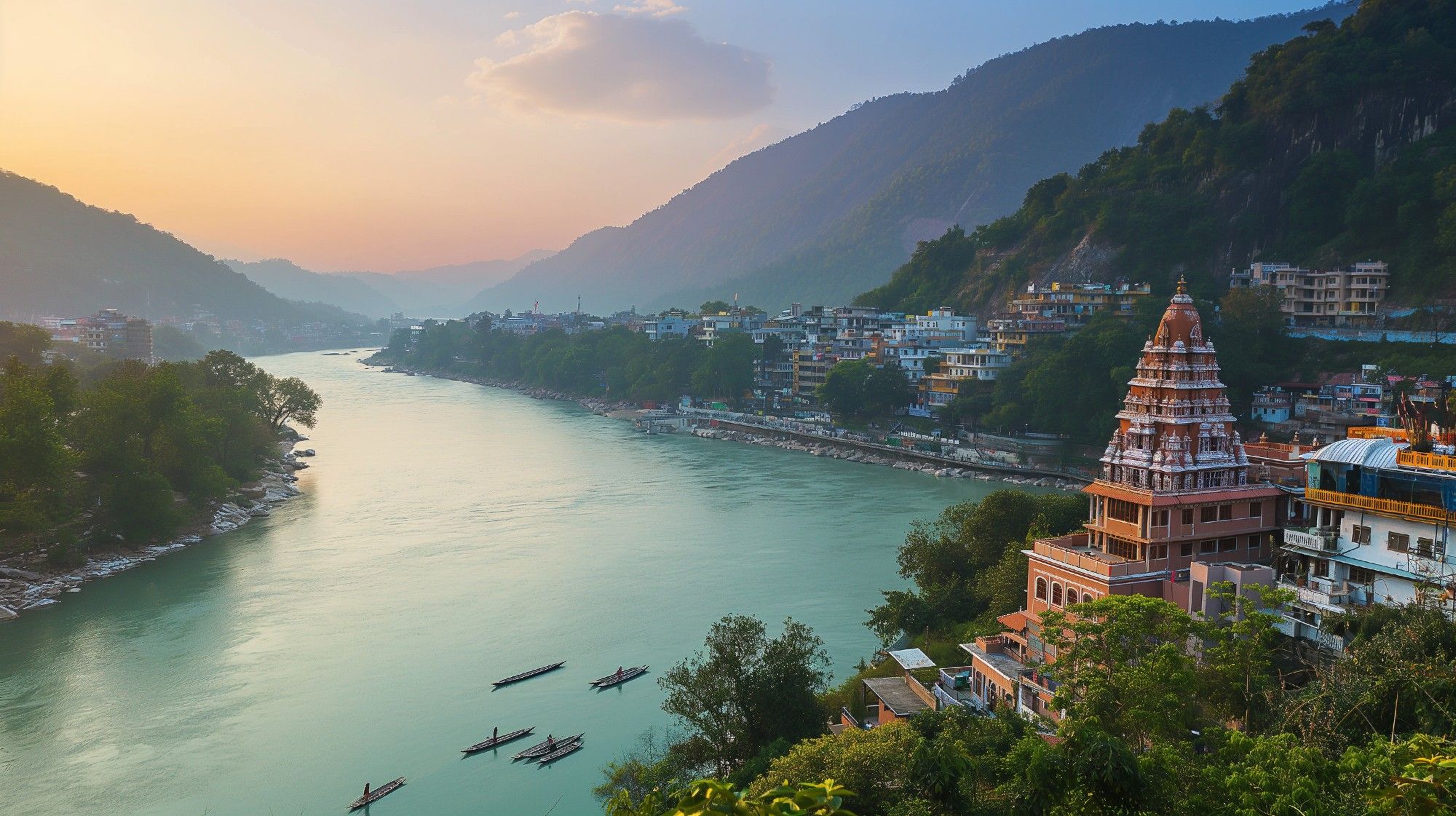 The Ganges River (India) flowing through a valley between mountains, with a large city on the banks and small boats floating near the shore