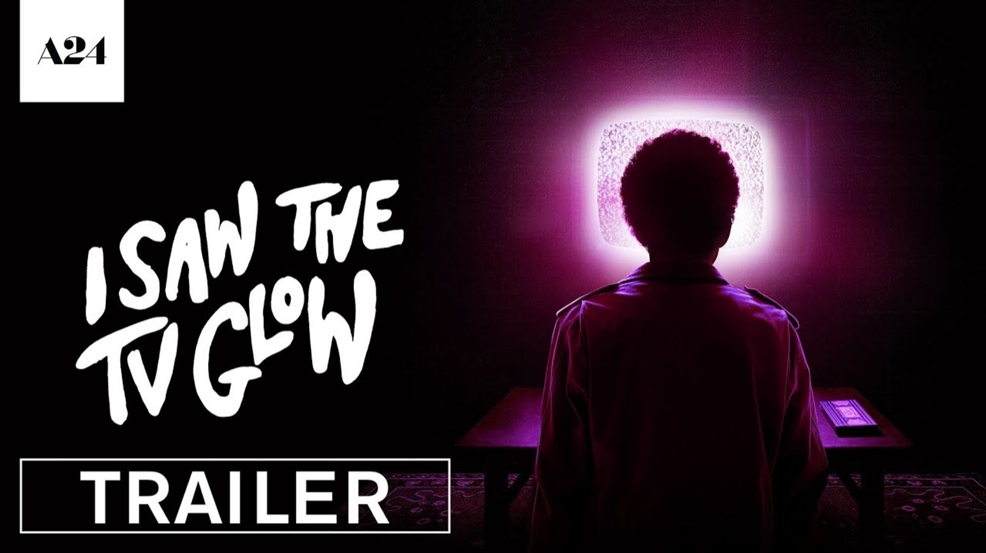 Title card for I Saw The TV Glow. A figure is silhouetted against the pink glow of a TV.