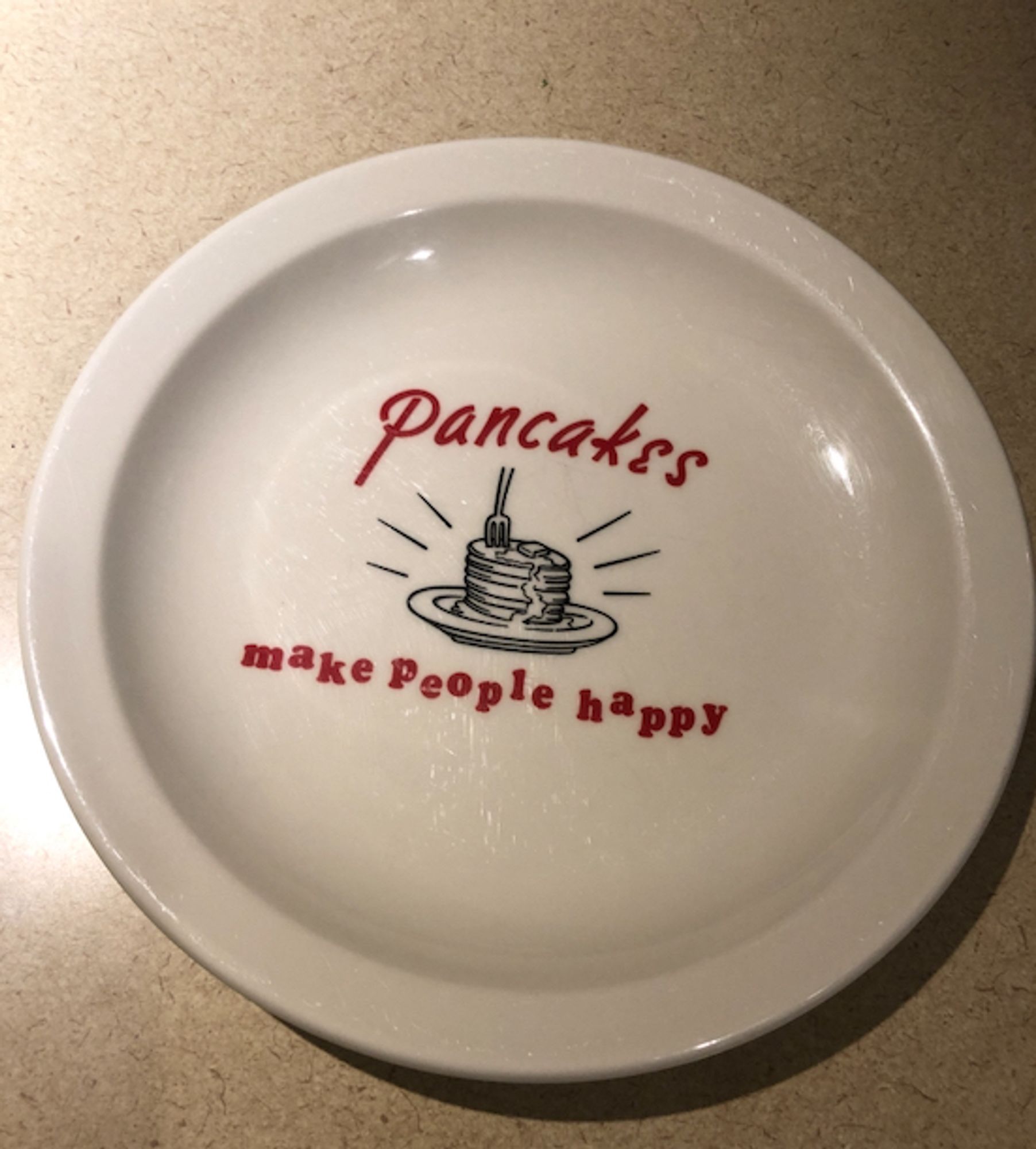 Large white plate with illustration of stack pancakes, with lettering declaring "Pancakes Make People Happy."