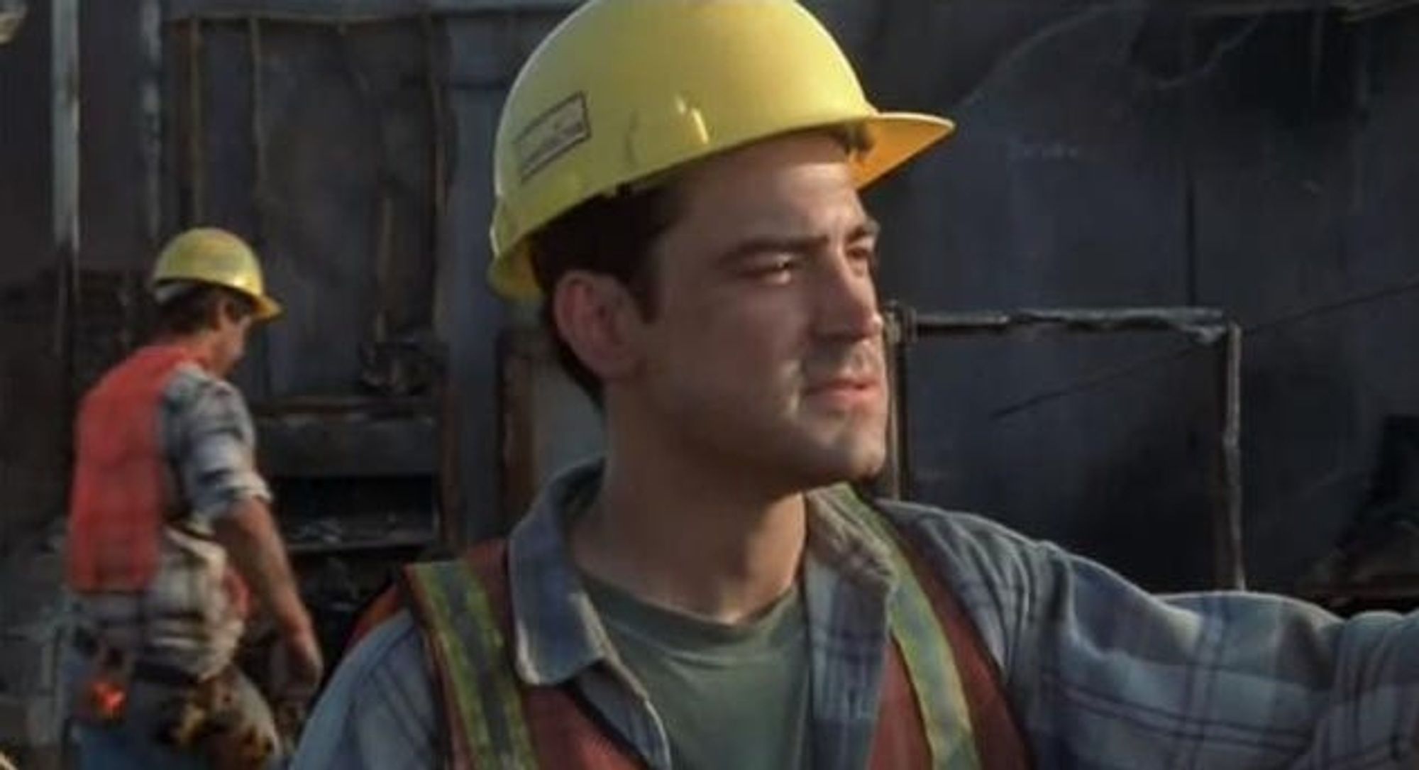 Peter at the end of officespace dressed as a construction worker clearing debris of the burned down office building, smiling into the distance with a thoughtful look in his eye