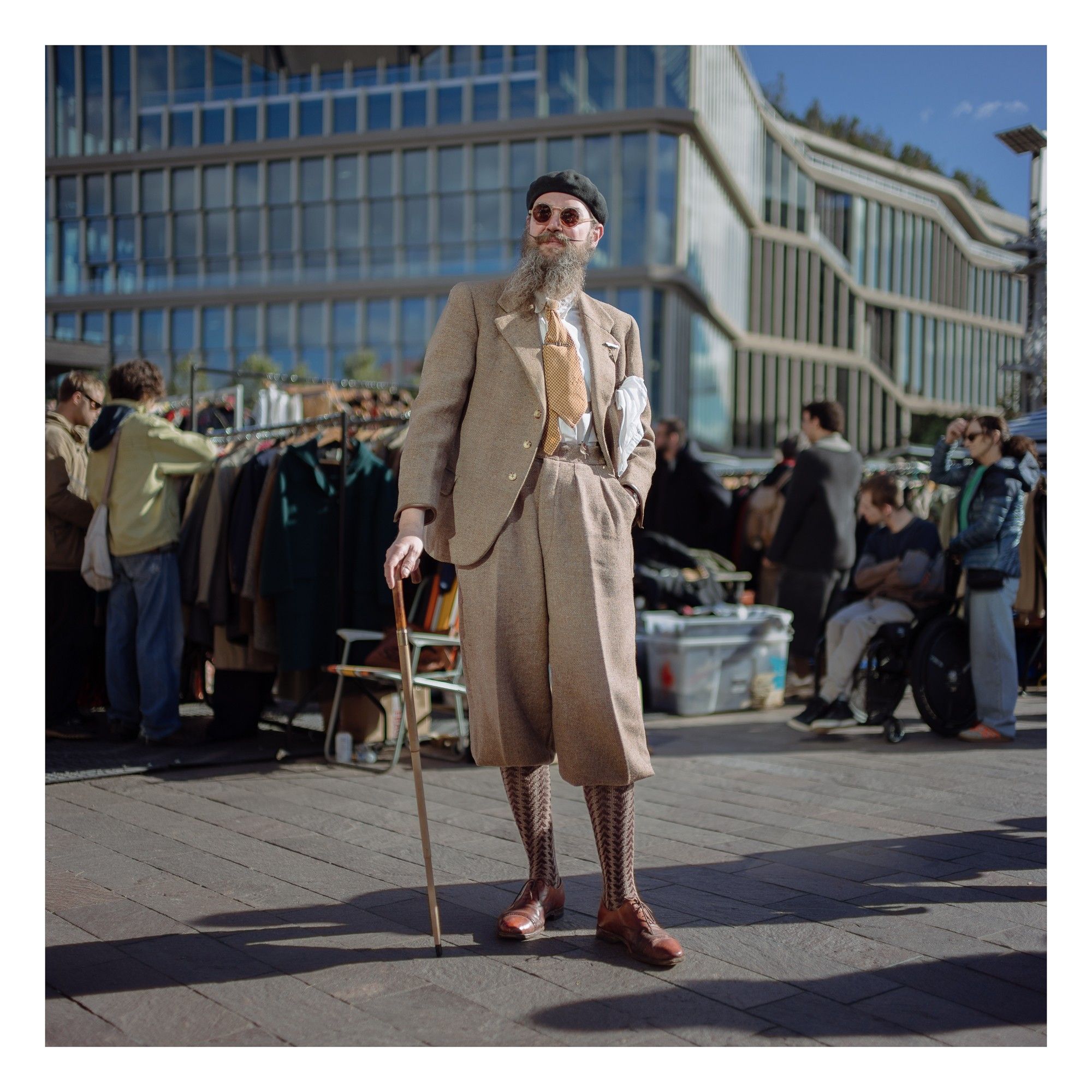 Portrait of a man in vintage clothing holding a cane.