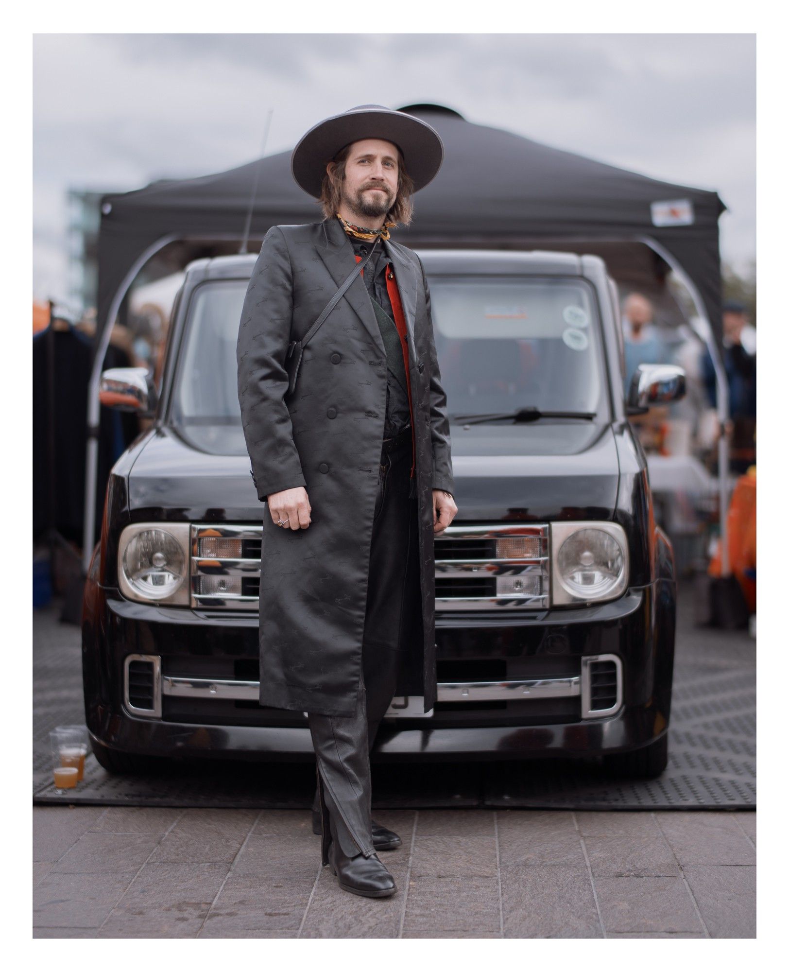 Portrait of a man in dark clothing and a wide-brim hat.