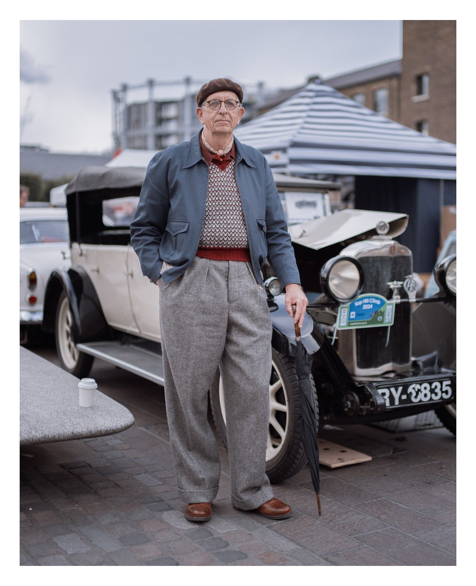 Portrait of a man in vintage clothing leaning on an umbrella.