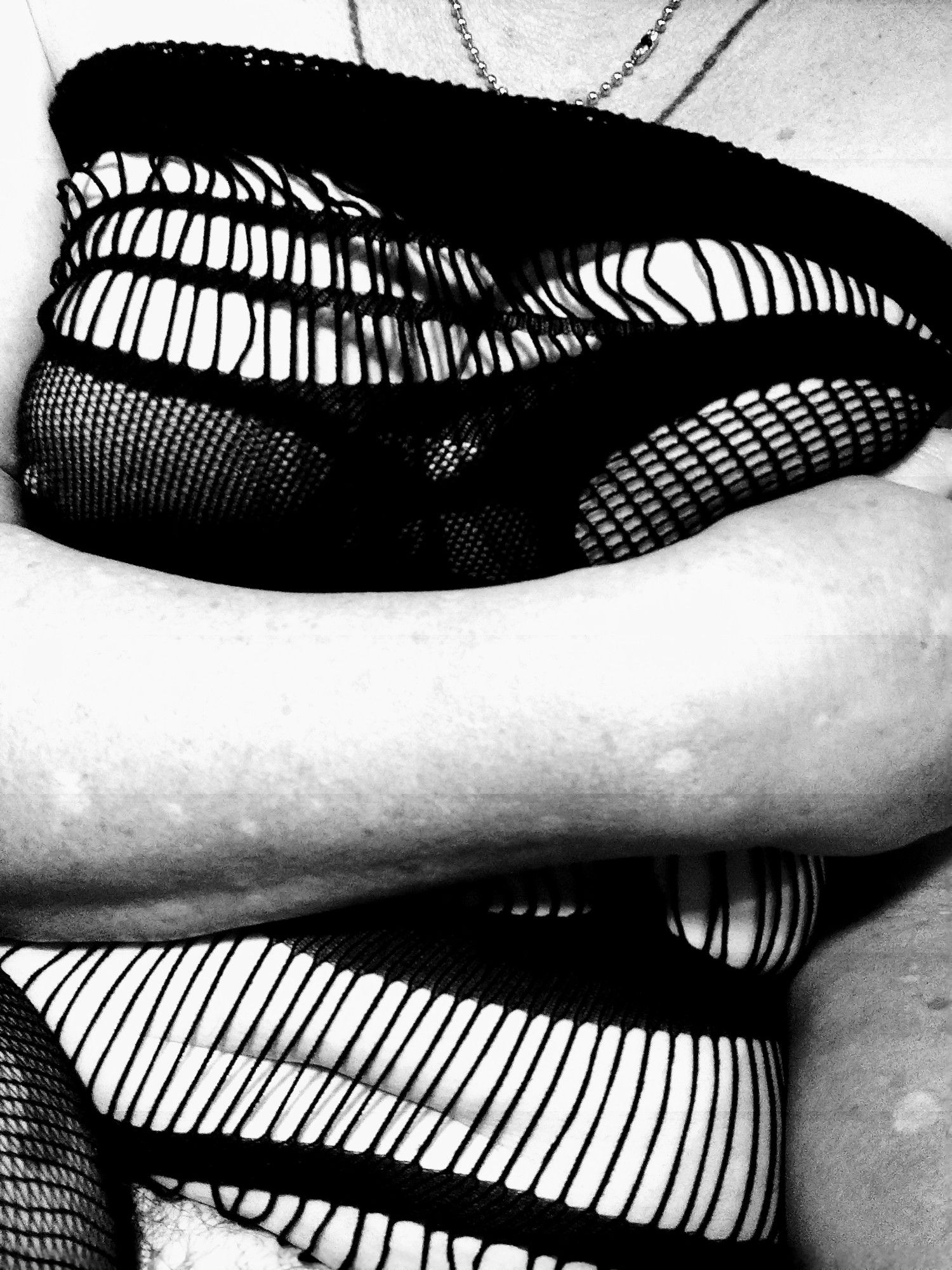 A black and white picture of a person in a body stocking. The shot is from tits to crotch .