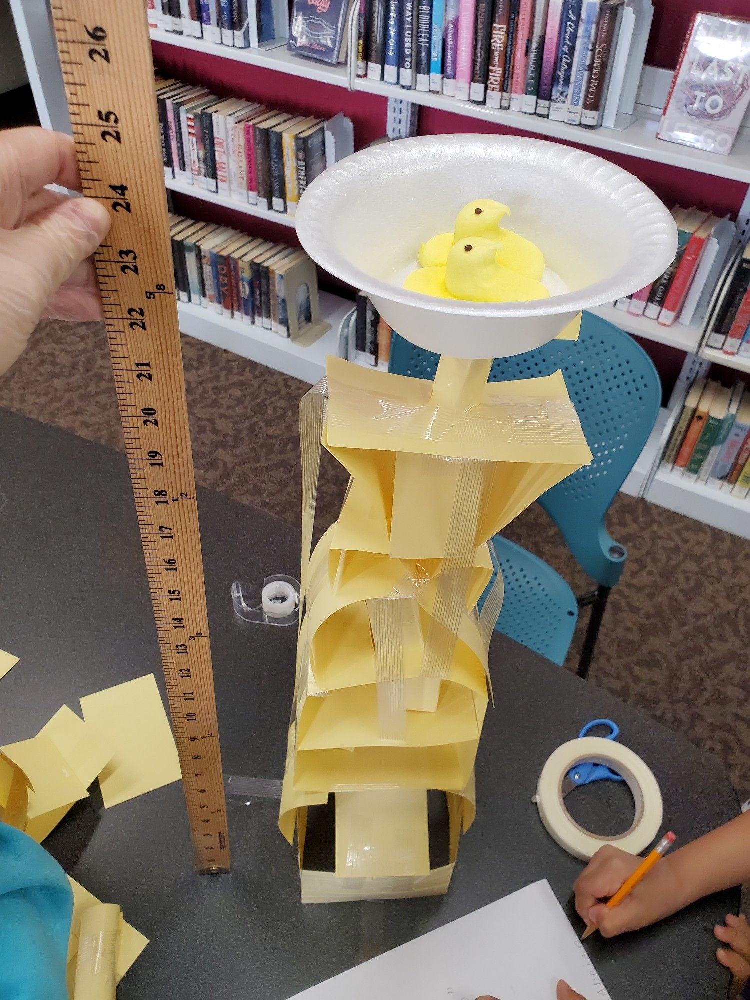 Photo: Two peeps in a plastic bowl nest sit atop an index card tower measuring 24 inches.