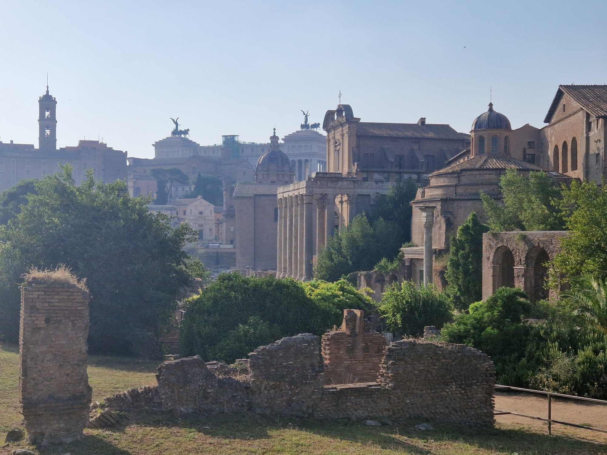 Photo looking west across the Forum in Rome, ruins stretching away into the glare of afternoon light