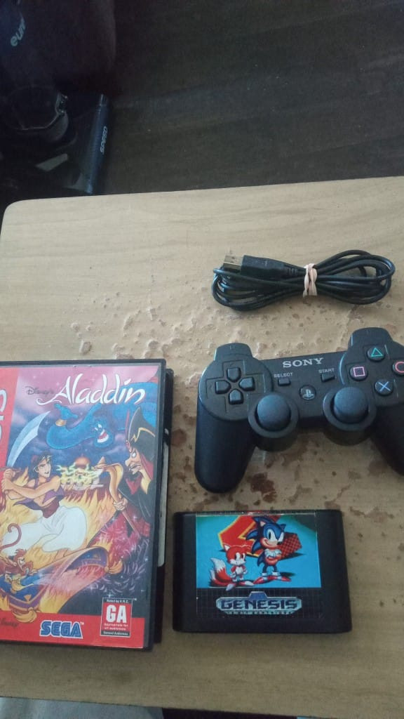 Aladdin on Genesis (boxed w/ manual), Sonic 2 (loose) and a Dualshock 3 w/ charging cable.