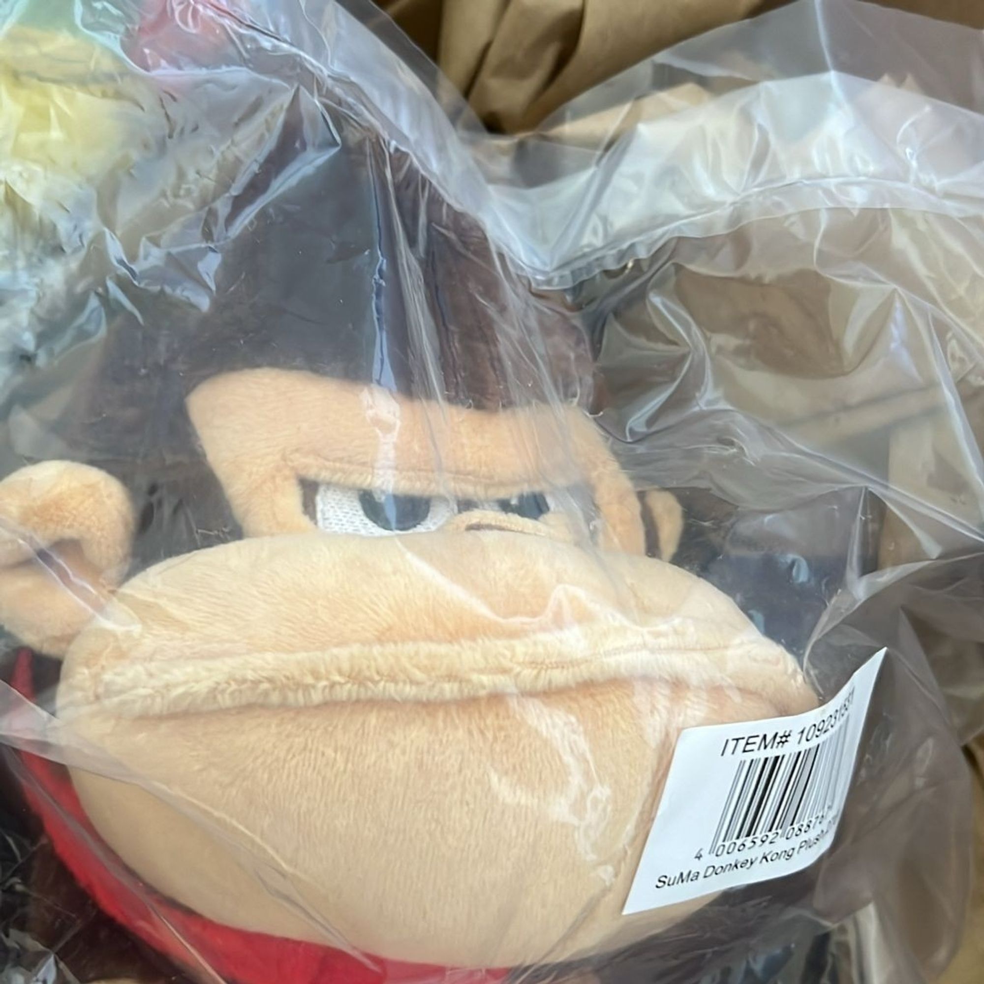 Een Donkey Kong pluche in de verpakking. Hij kijkt niet blij