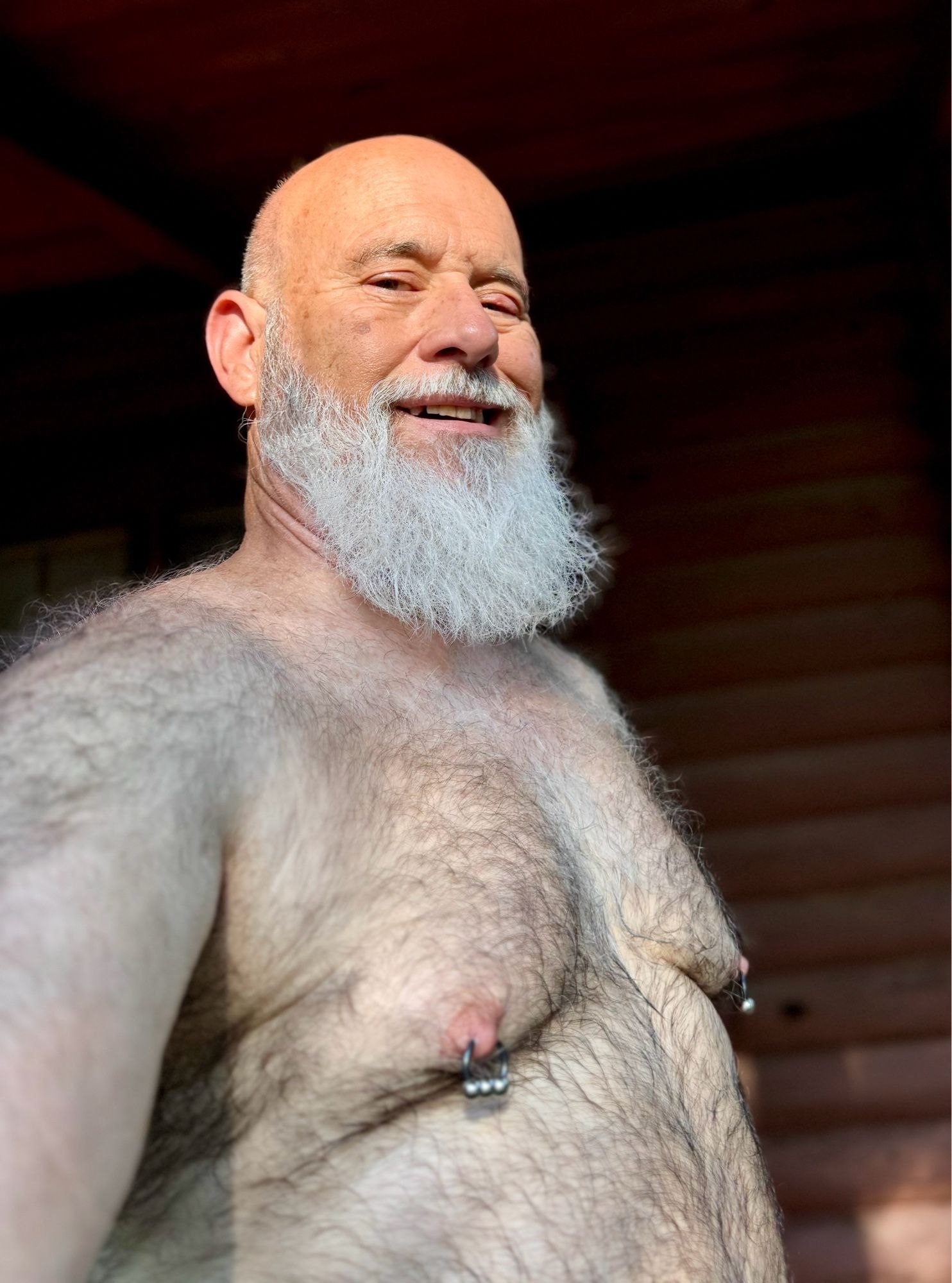 Shirtless man with a white beard, facing the camera, lit by sunshine. NO GENITALIA SHOWING.