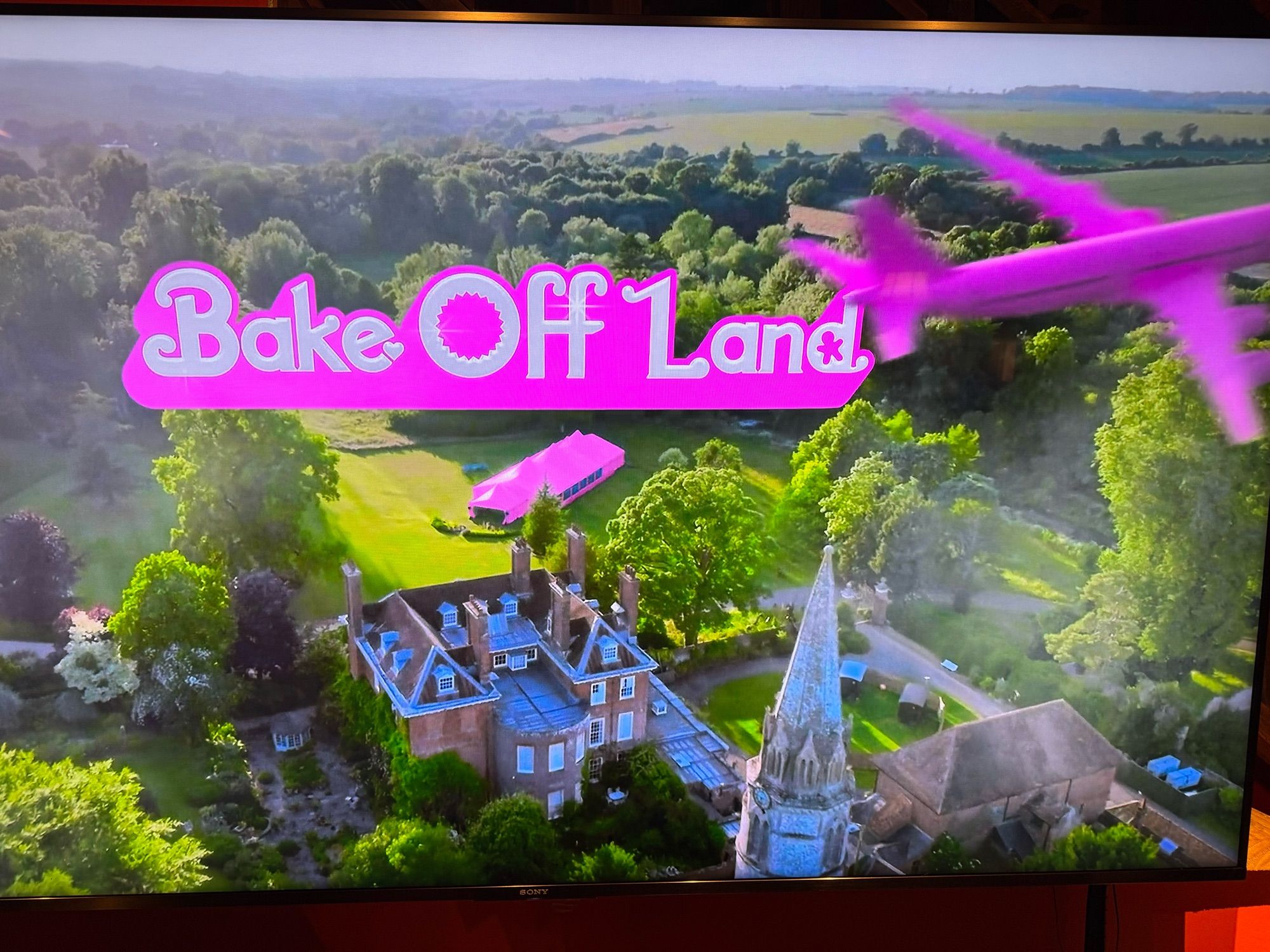 A screenshot from the Great British Baking Show making a play on Baerbie with a pink tent and jet