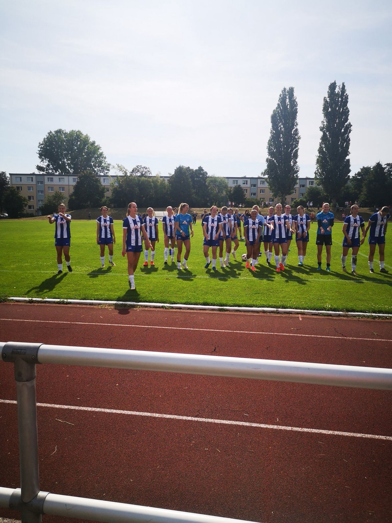 Das Team der HerthaFrauen steht nach dem Spiel am Spielfeldrand und wird von den mitgereisten Fans gefeiert