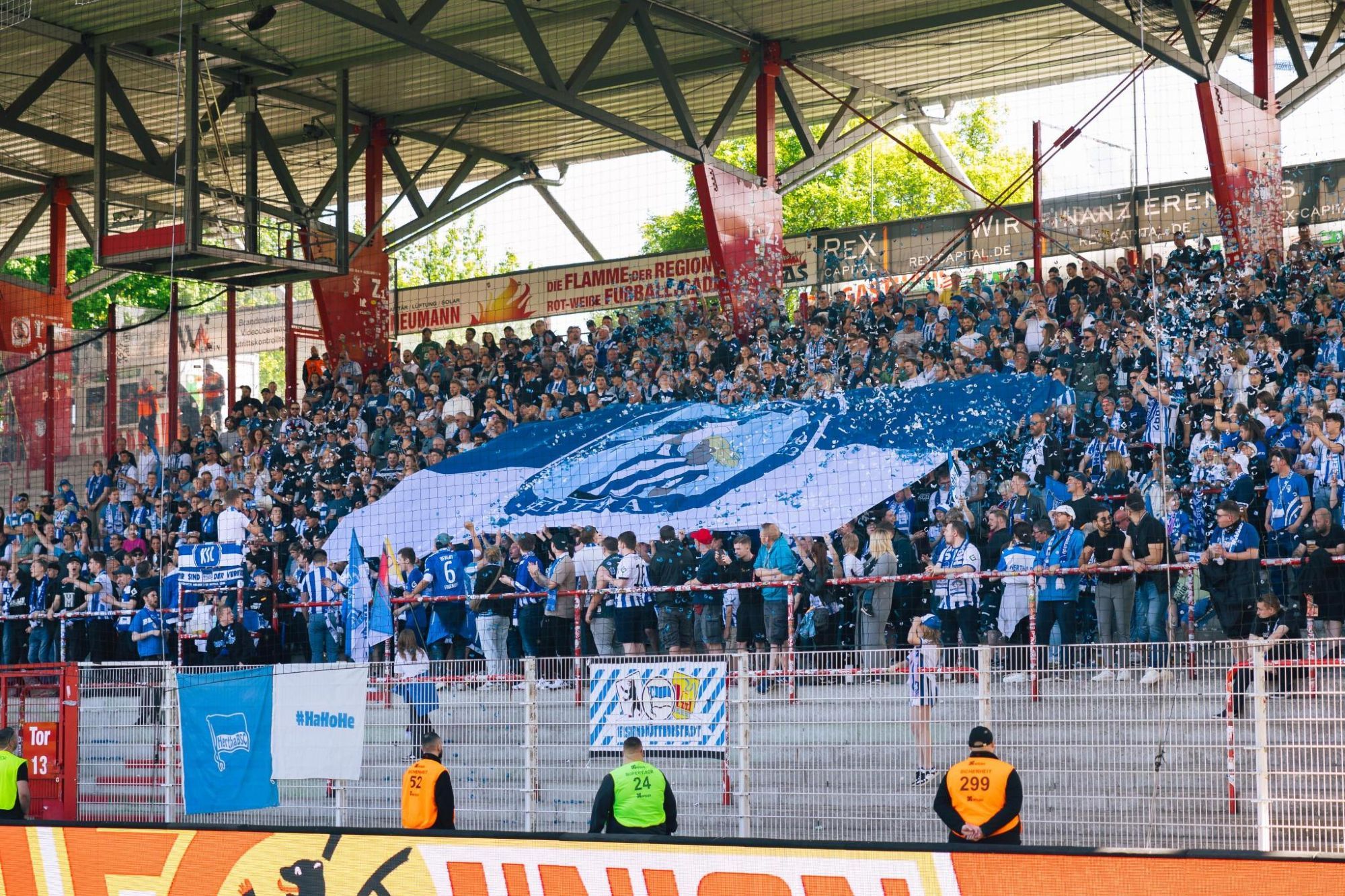 Blick in den Auswärtsblock beim Derby mit Blockfahne und ganz viel blau-weißem Konfetti