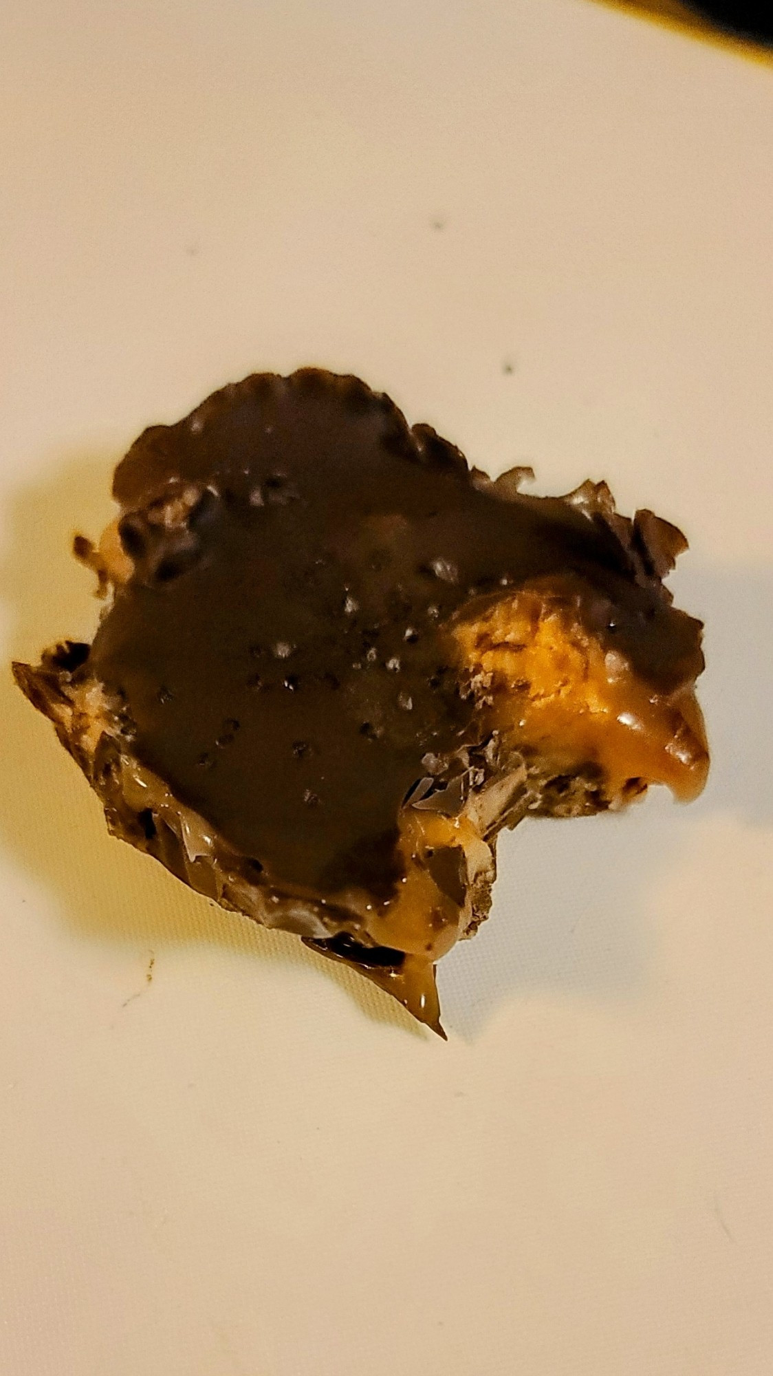 A homemade chocolate peanut butter cup with caramel filling