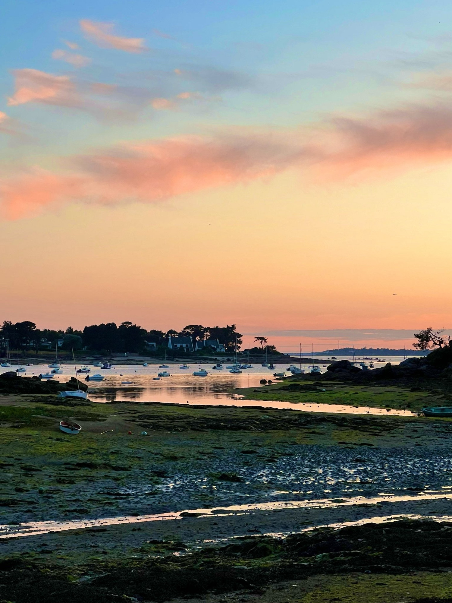 Vue sur la ria après le coucher du soleil, le ciel est rose orange et se reflète sur la mer