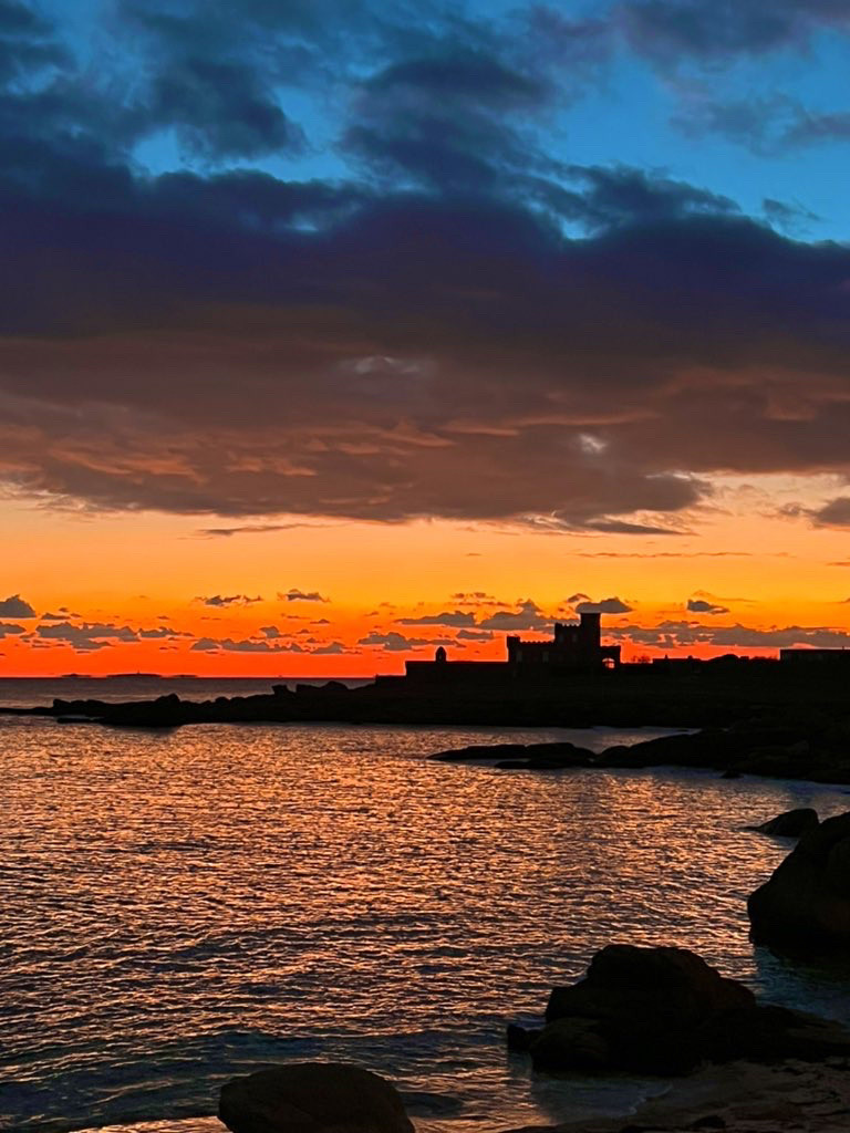 Coucher de soleil sur le fort de Trevignon le ciel est rouge noir et bleu et se reflète dans la mer