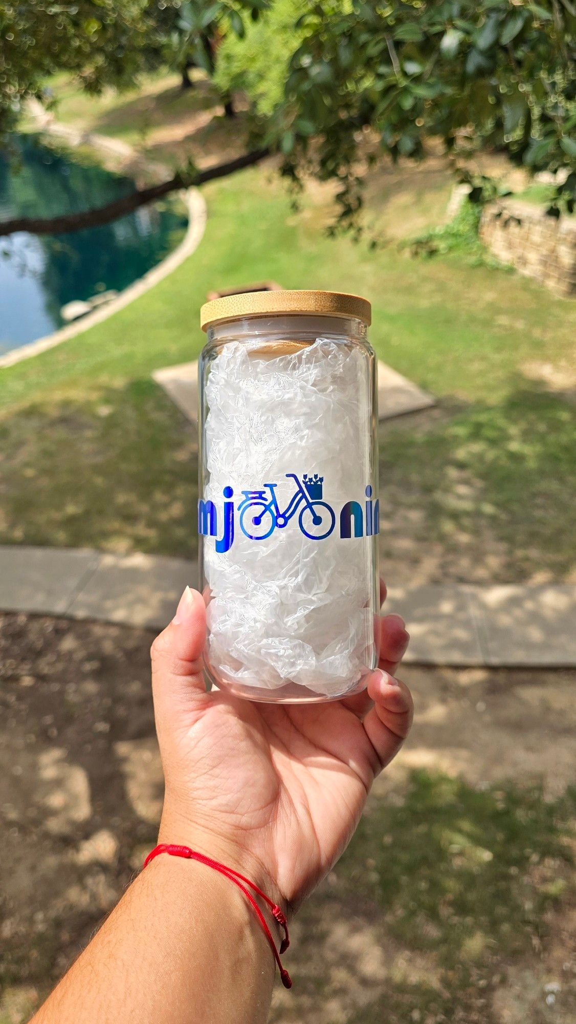 Can-shaped glass cup with the word 'Namjooning' on in holographic blue permanent vinyl. The double 'o' in the word was replaced with a little bycicle