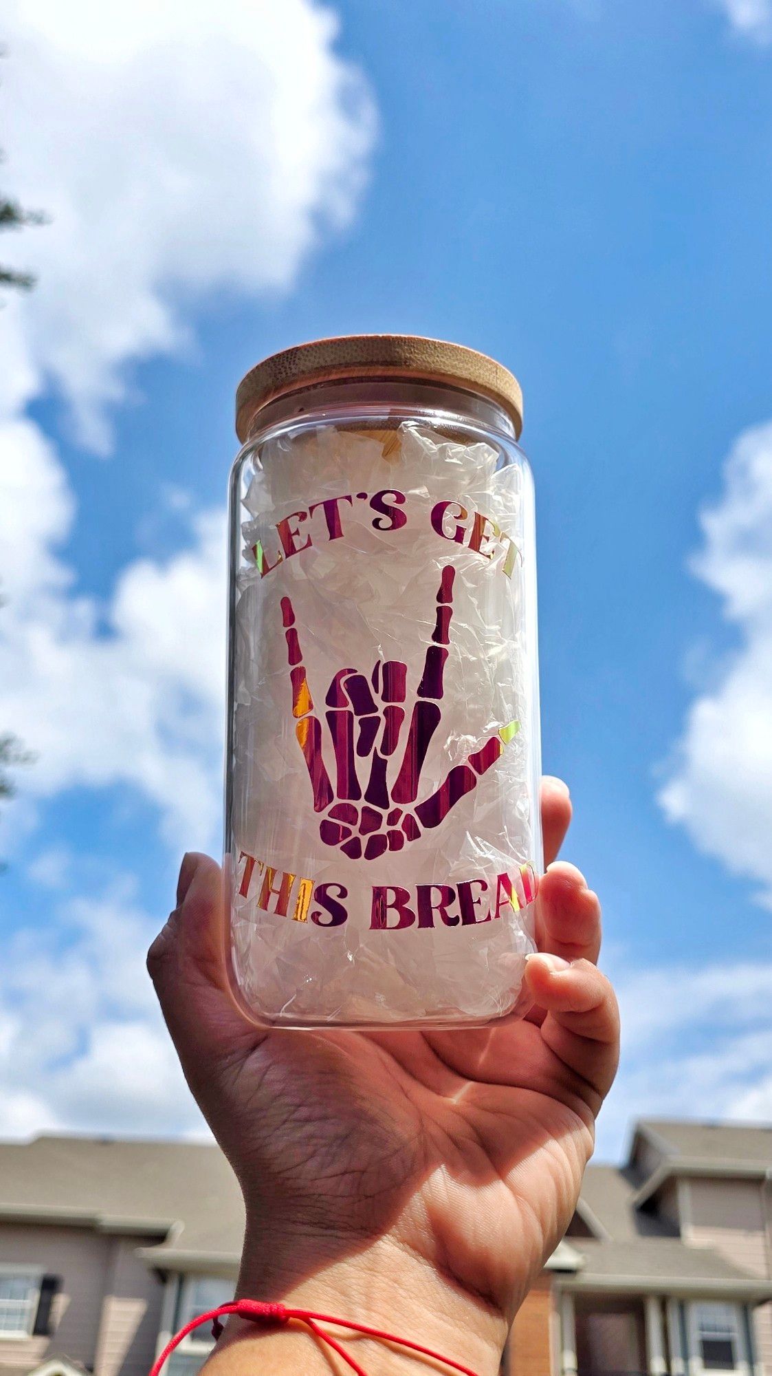 Can-shaped glass cup with the phrase "let's get this bread" and a skeleton hand making the "I love you" sign in language sign on the cup in permanent "orchid purple" vinyl