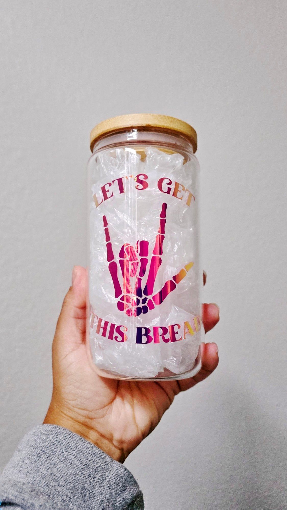 Can-shaped glass cup with the phrase "Let's get this bread" and a skeleton hand making the "I love you" sign in language sign on the cup in permanent "orchid purple" vinyl