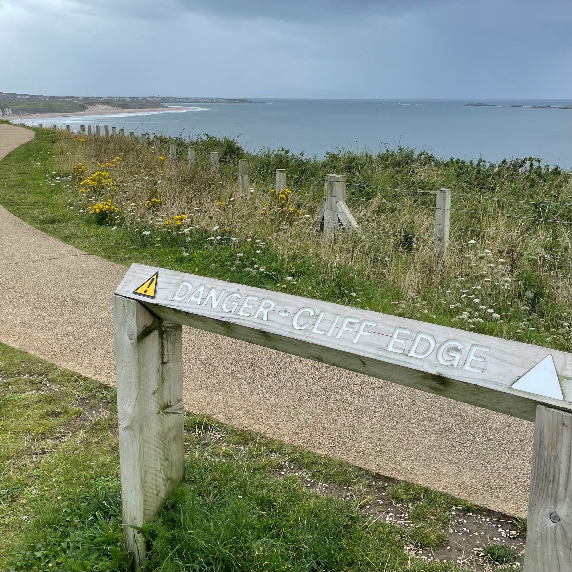 Danger - Cliff edge sign with sea in distance