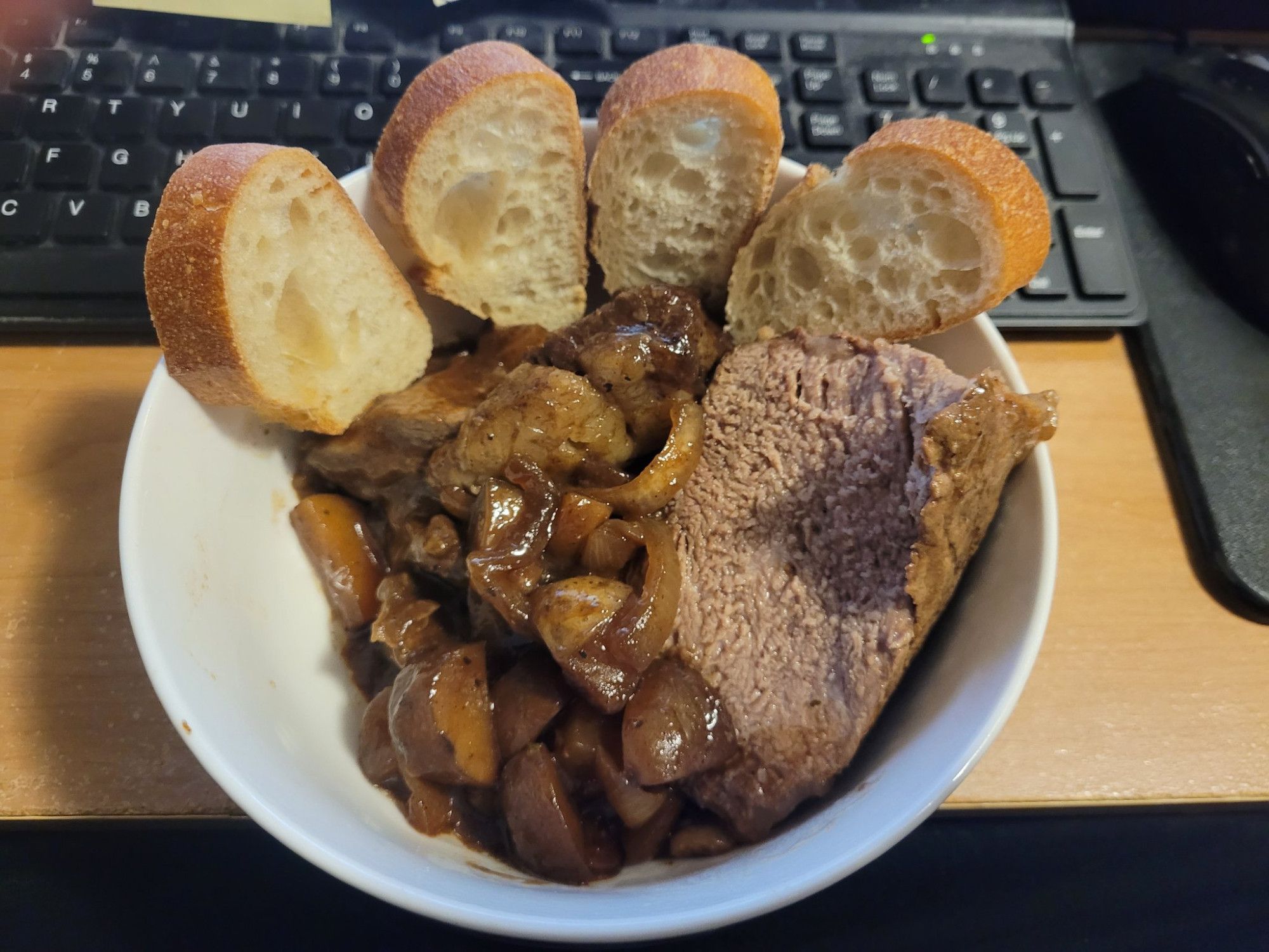 four slices of baguette, some pot roast and some potatoes in a bowl, arranged like a chunky five-fingered open palm