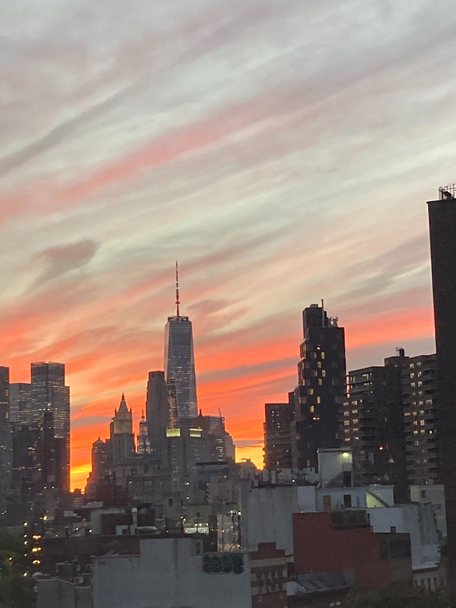 Lower Manhattan against a dramatic orange and pink sunset.