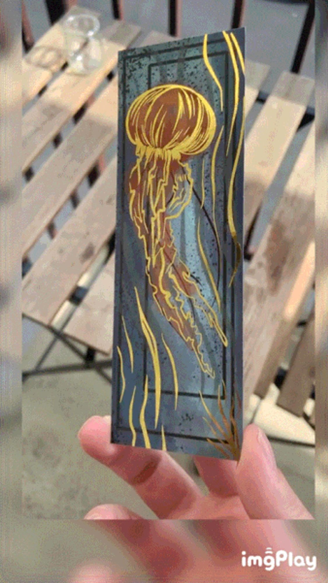 a bookmark featuring a jellyfish picked out in gold foil