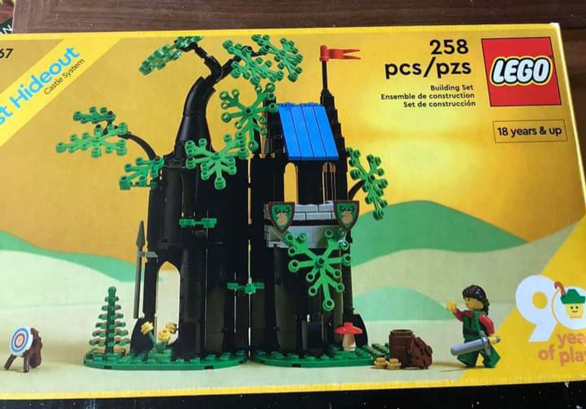 Box cover of the 2022 LEGO set Forrest hideout. The box labelled as 18 years and up, despite being modern recreation of kids set from 1988. The build is a large hollow tree that has a small house built on the top.